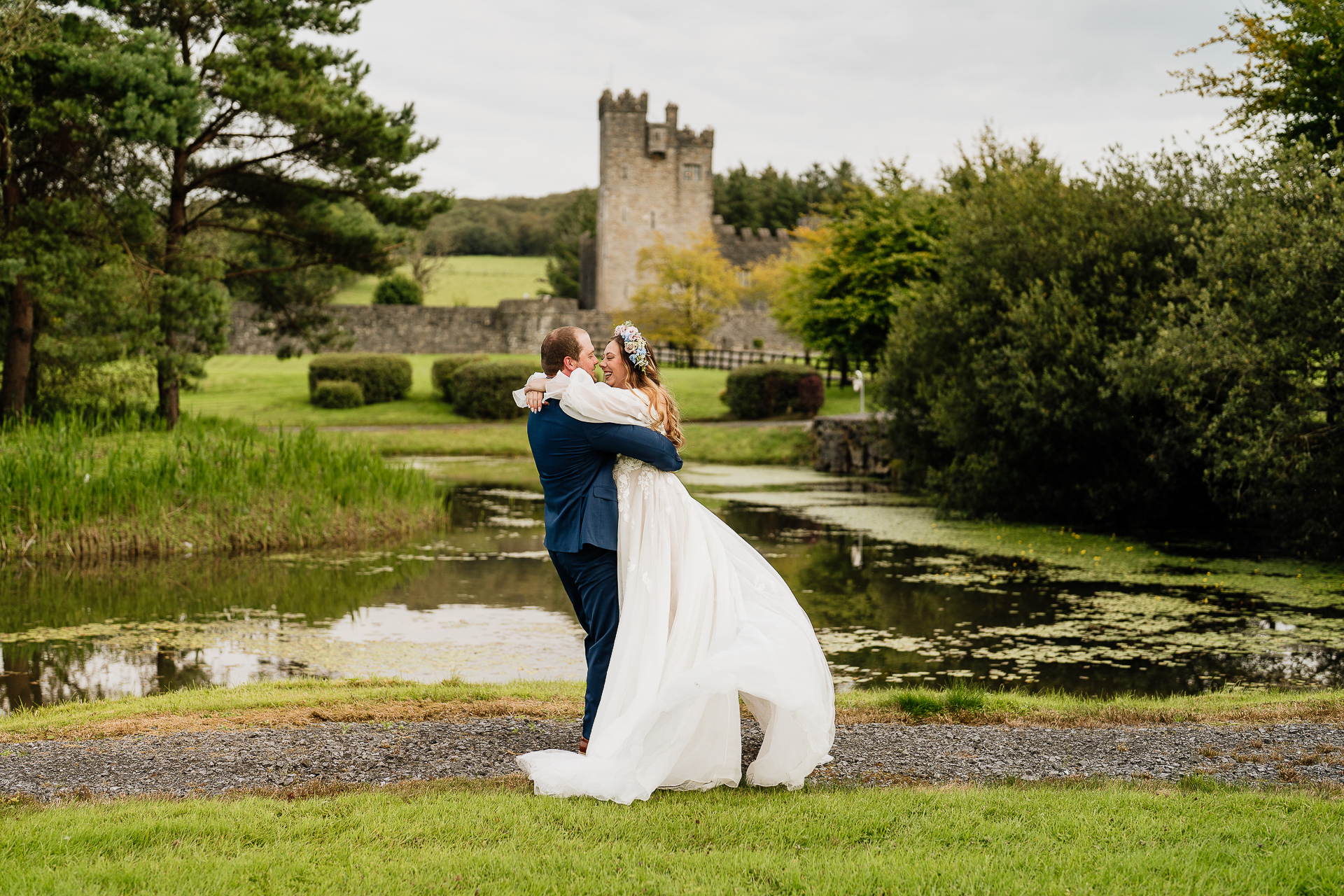 A man and woman kissing in front of a castle