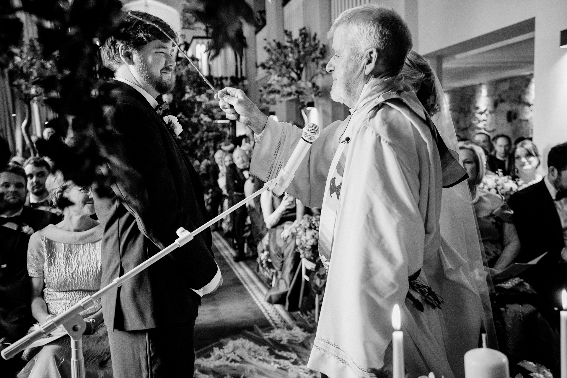 A person in a white robe and cap talking to a person in a robe