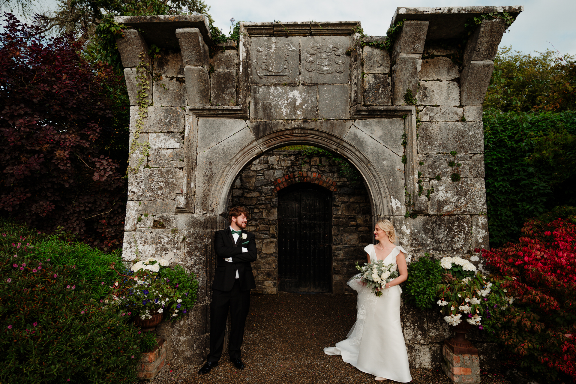 A bride and groom in front of a stone building