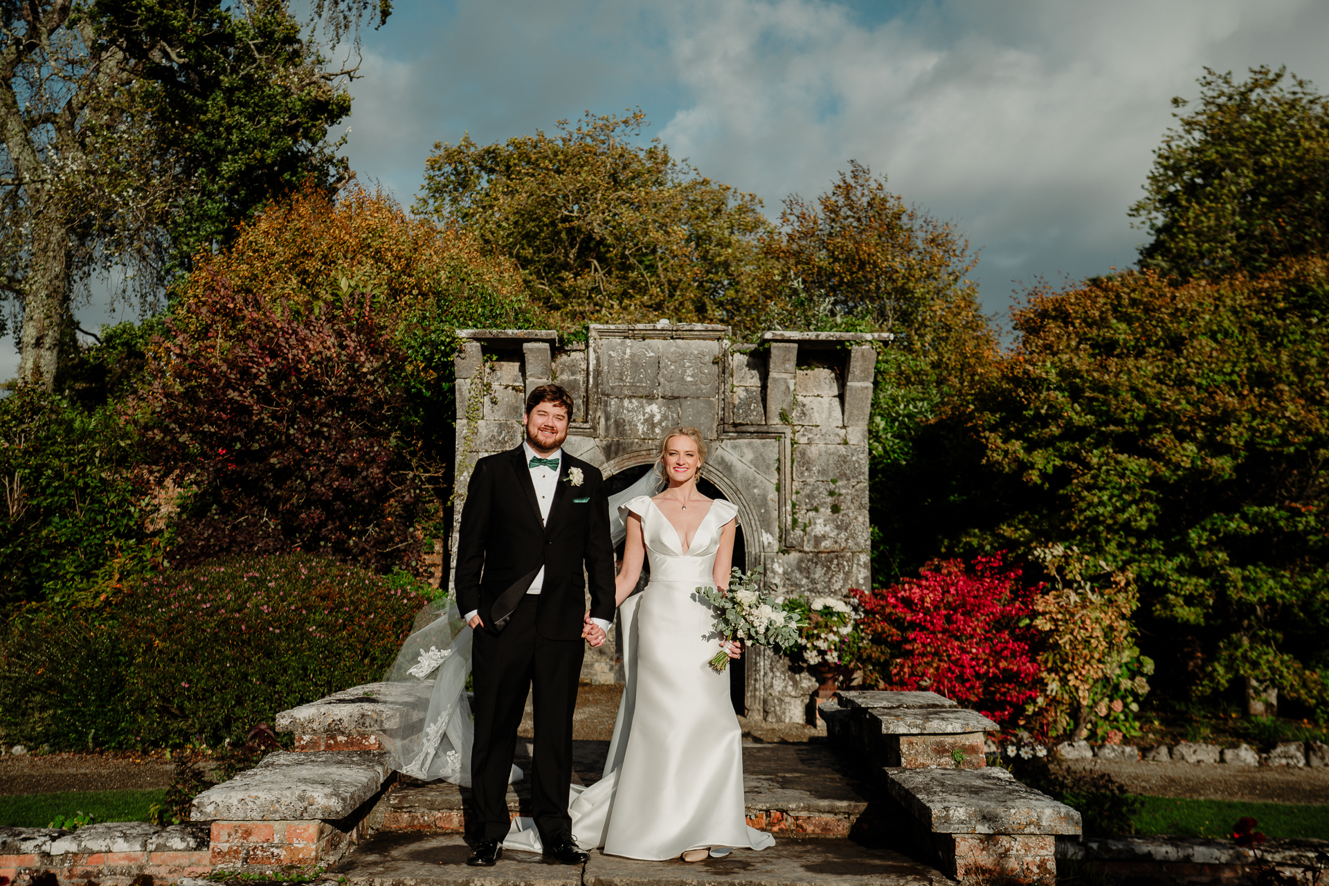 A man and woman posing for a picture in front of a stone structure