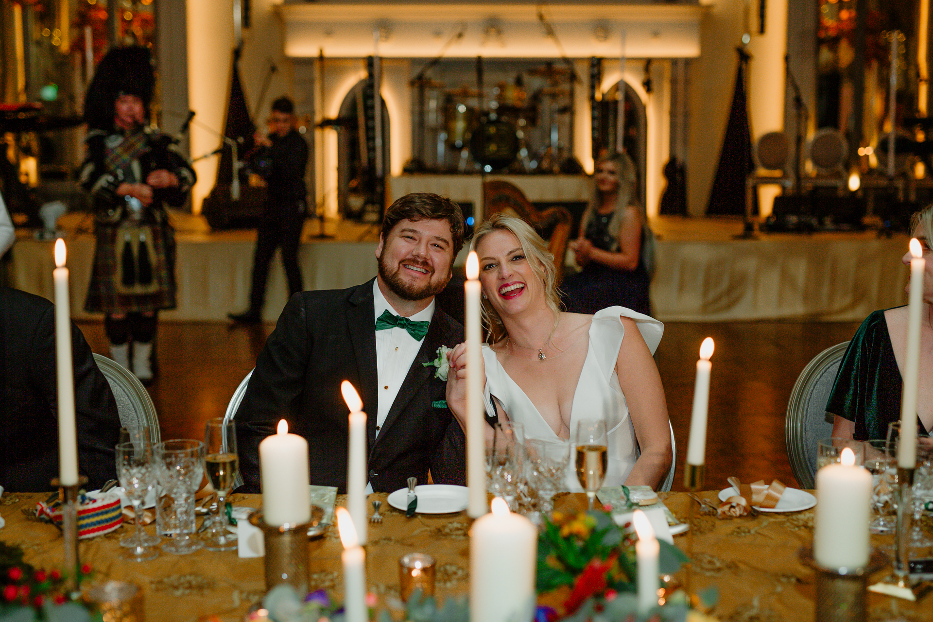 A man and woman sitting at a table with candles and glasses