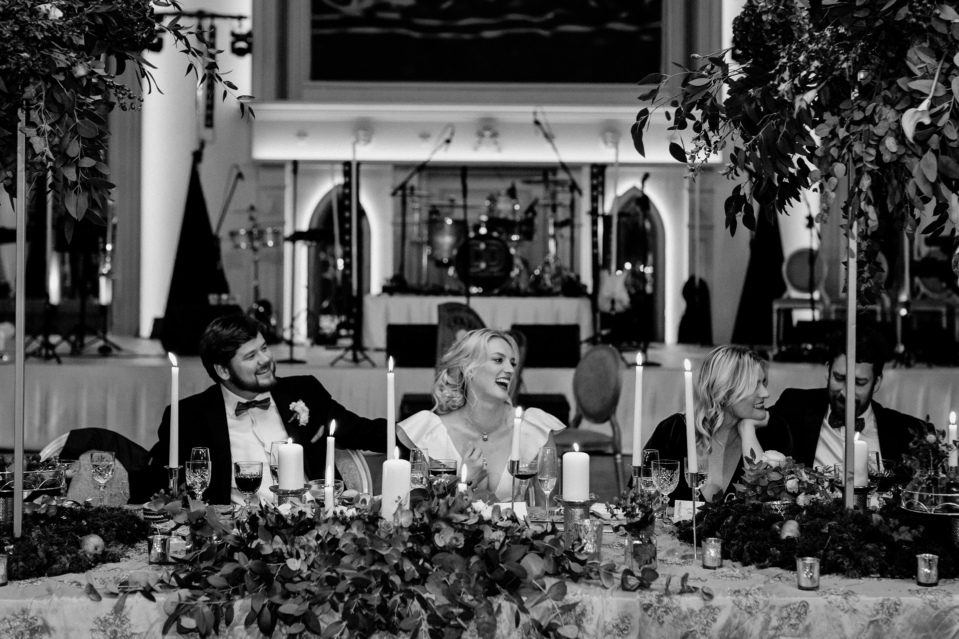 A man and woman sitting at a table with flowers and candles