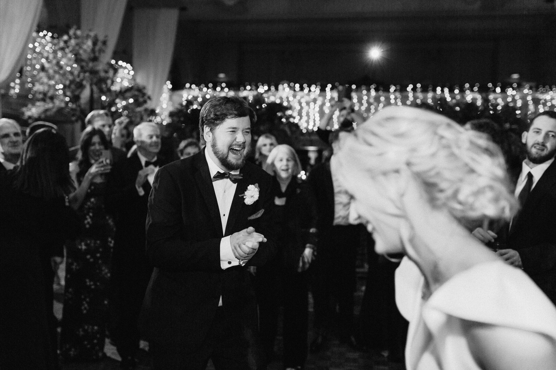 A person in a tuxedo dancing with a crowd of people