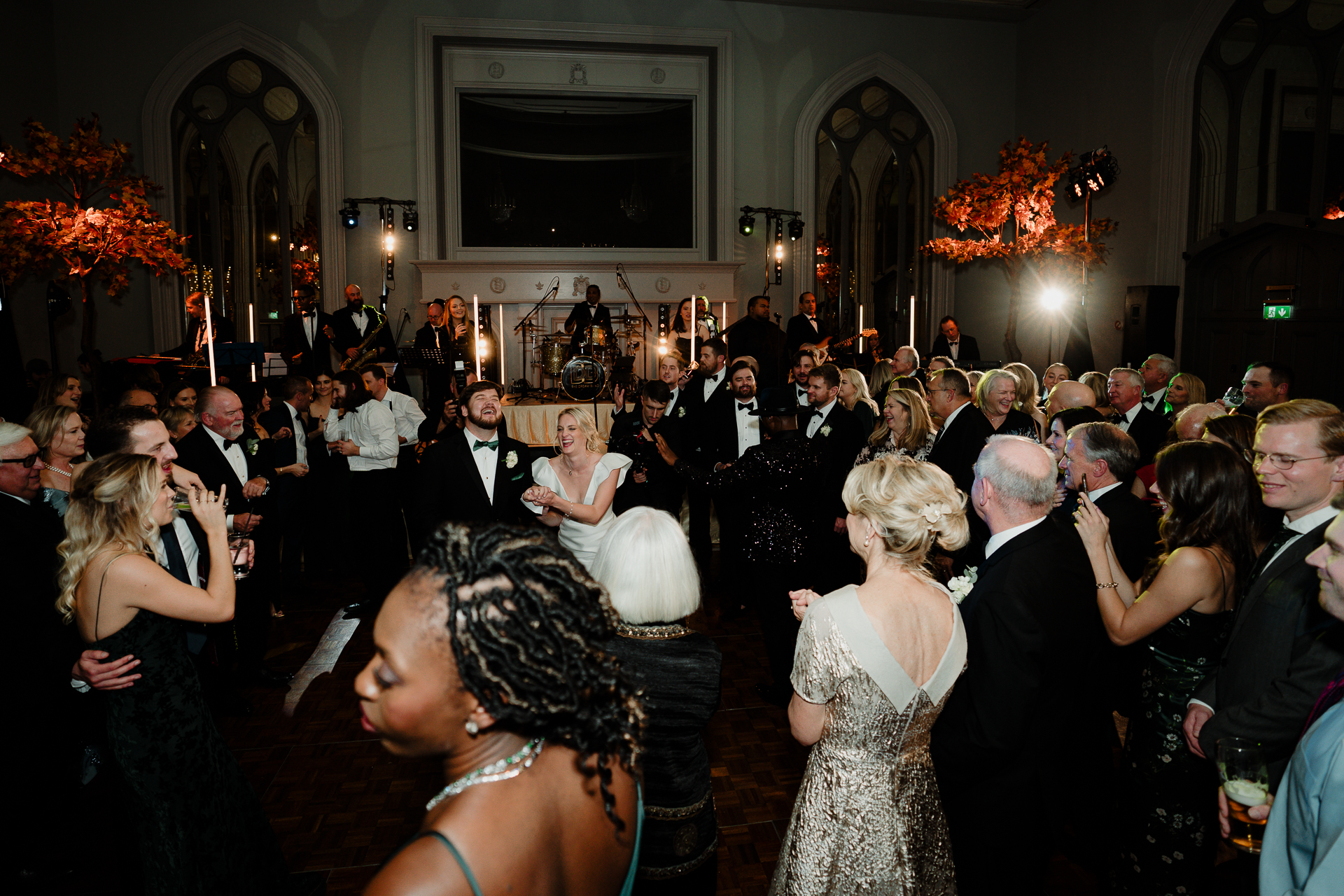 A group of people dancing in a room with a large chandelier