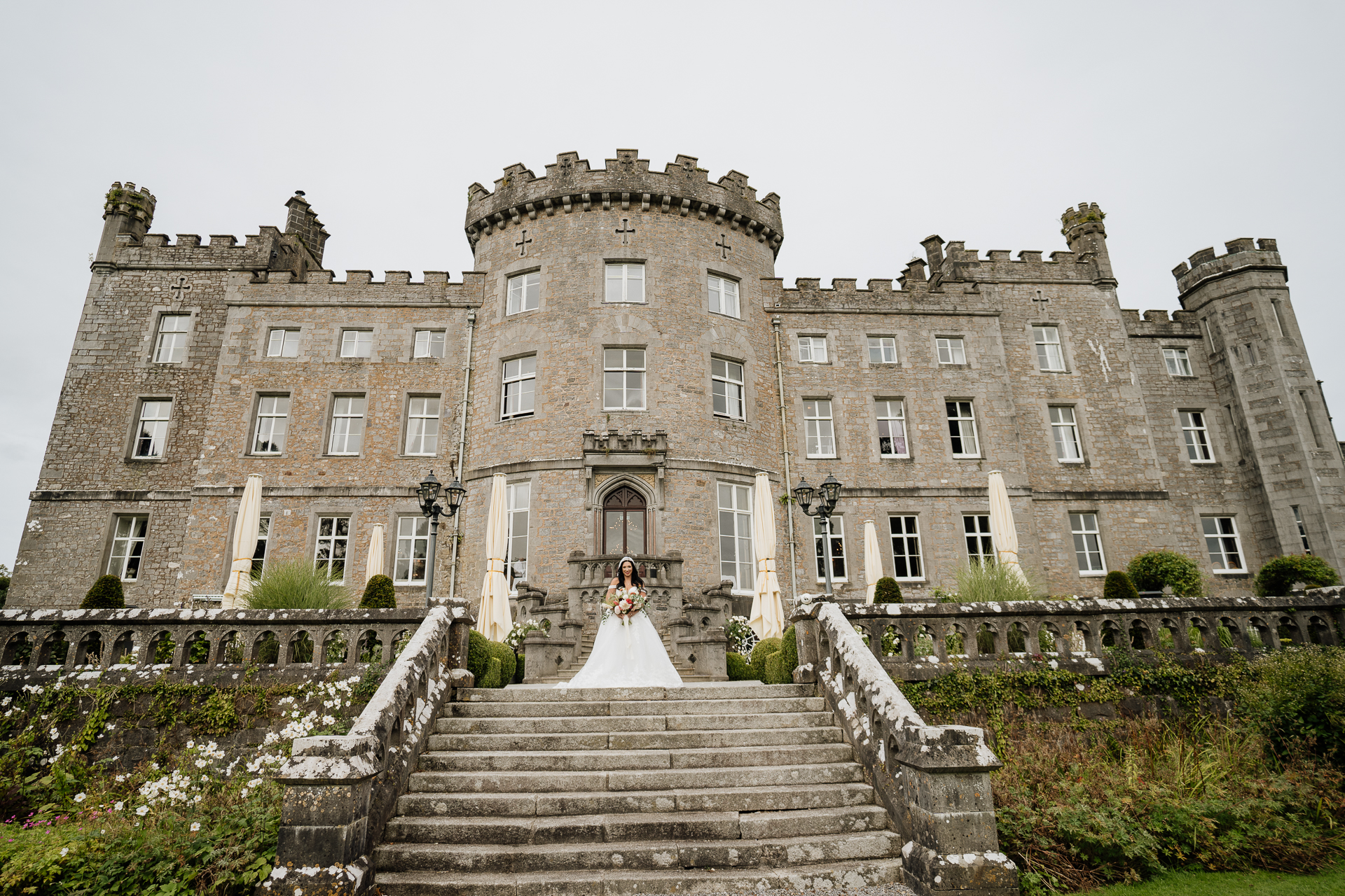 A large building with stairs and a statue in front of it with Bowes Museum in the background