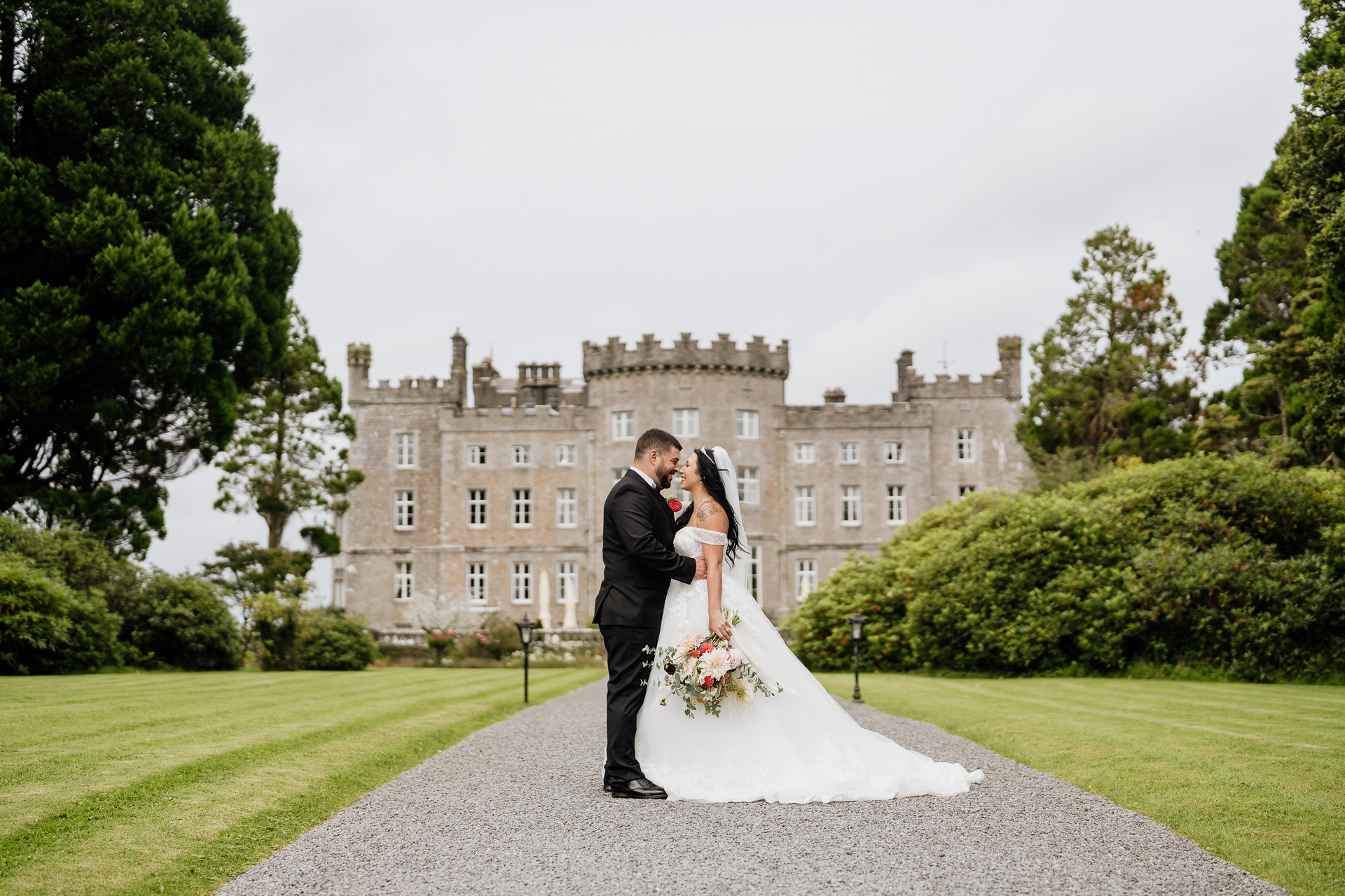 A man and woman in wedding attire standing in front of a large building