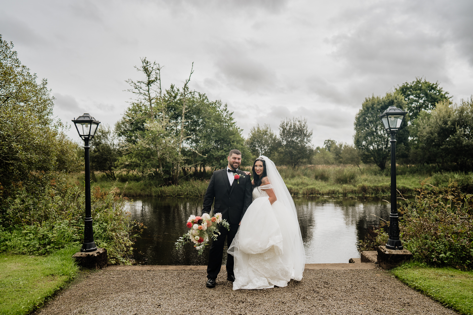 A man and woman posing for a picture next to a pond