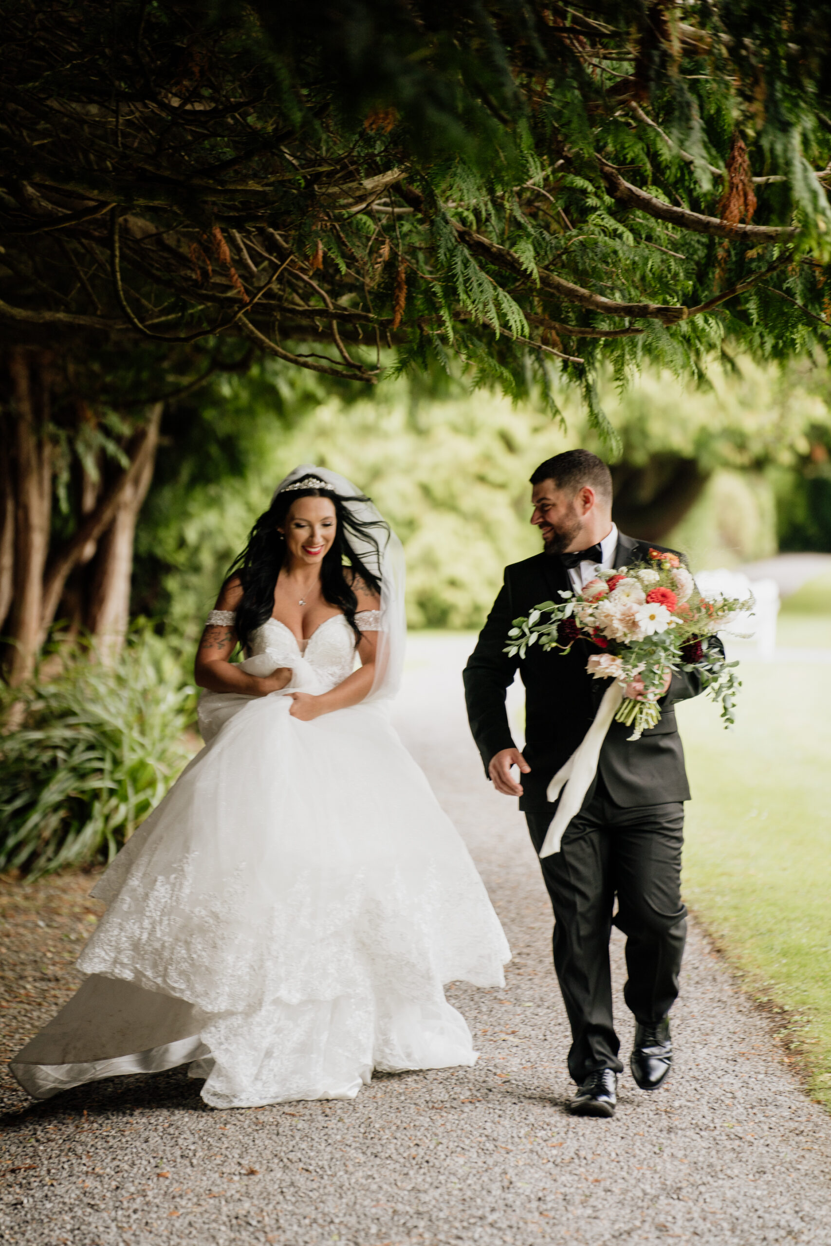 A man and woman walking down a path with flowers