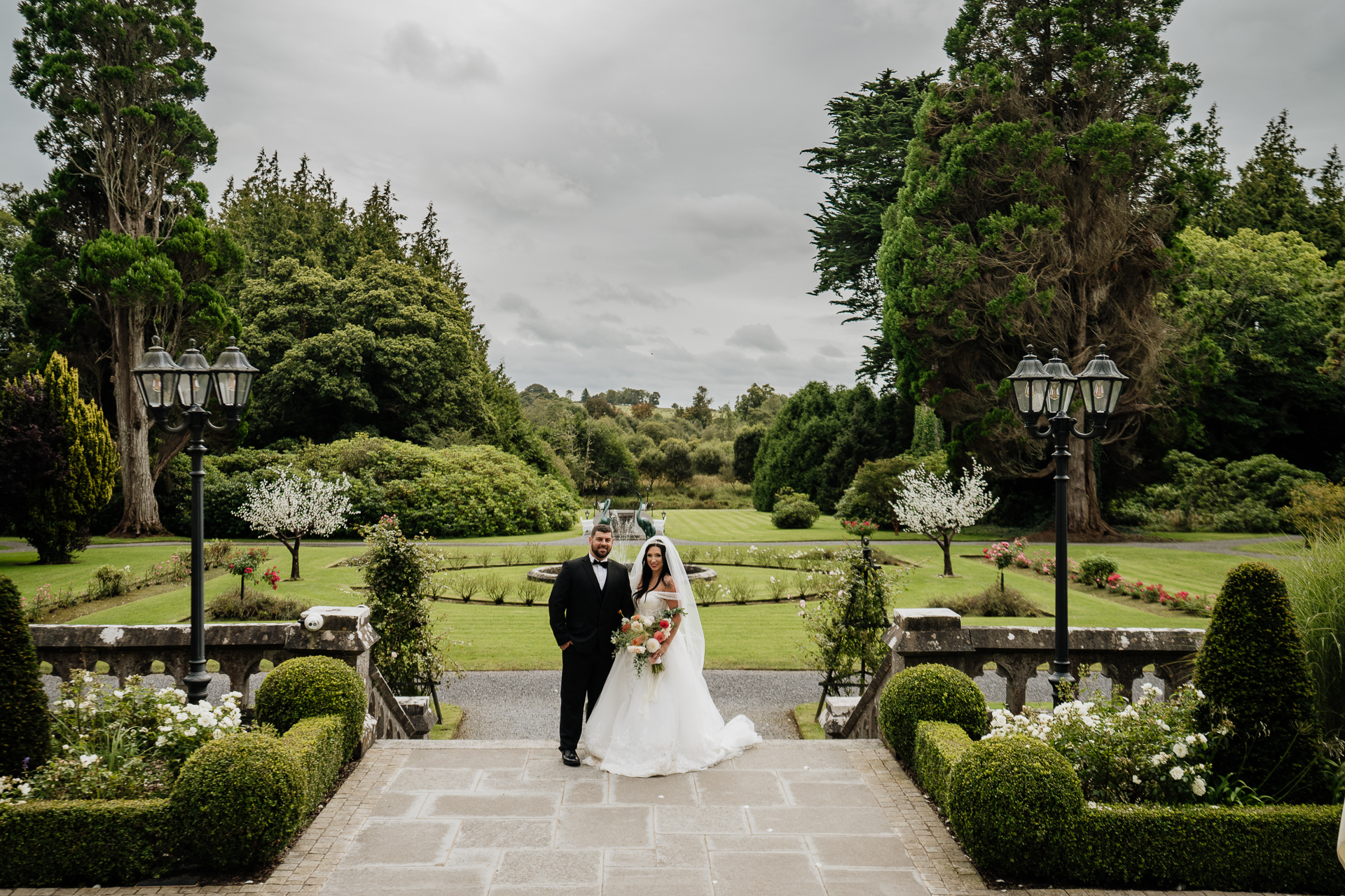 A man and woman posing for a picture in a garden