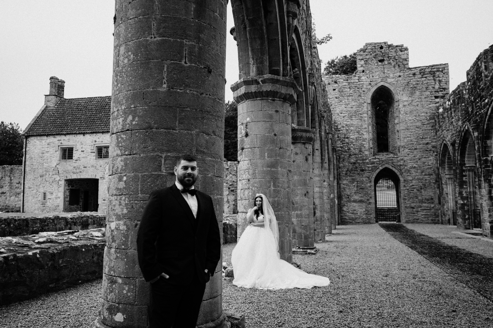 A bride and groom in front of a stone building