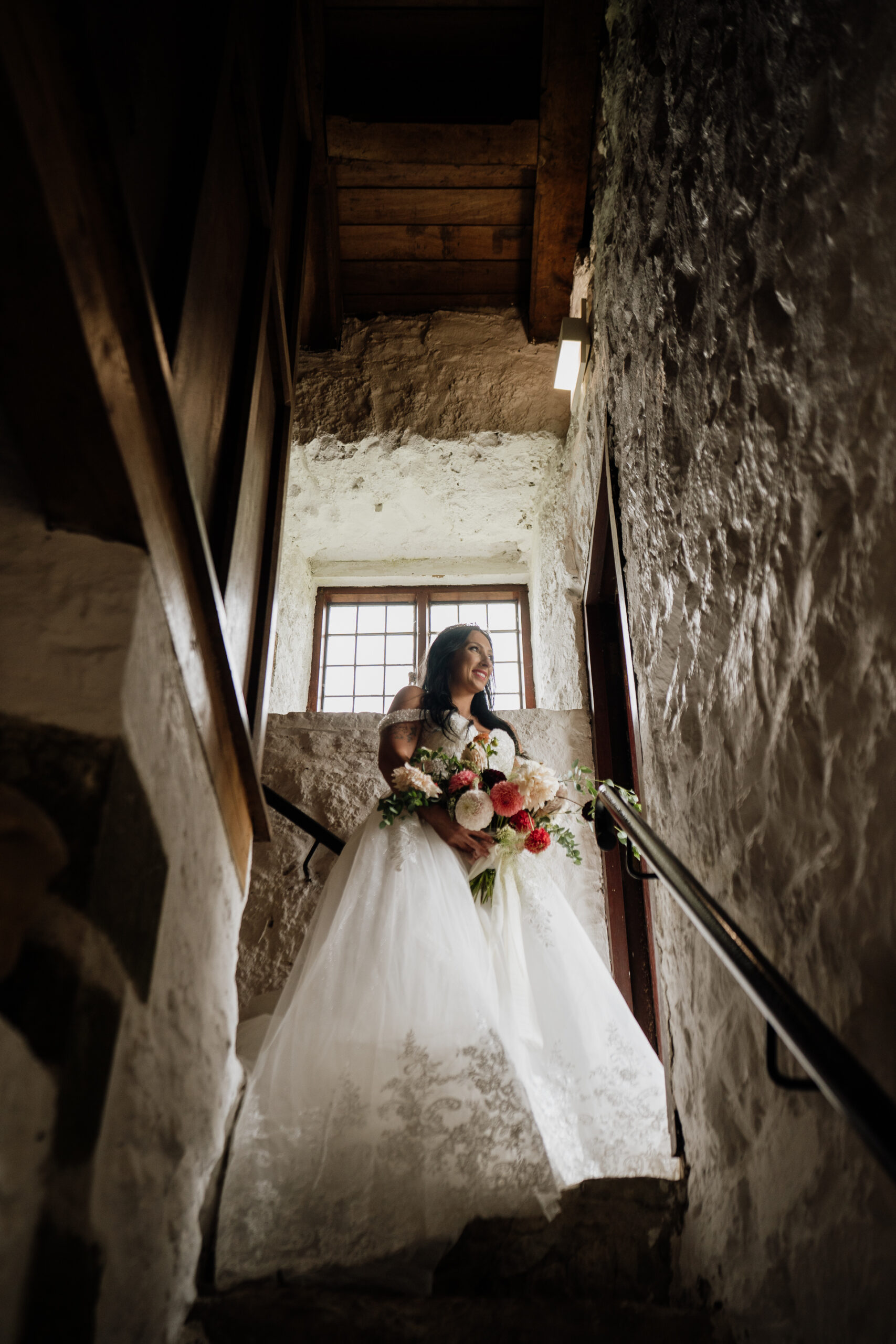 A person in a white dress holding a bouquet of flowers in a doorway