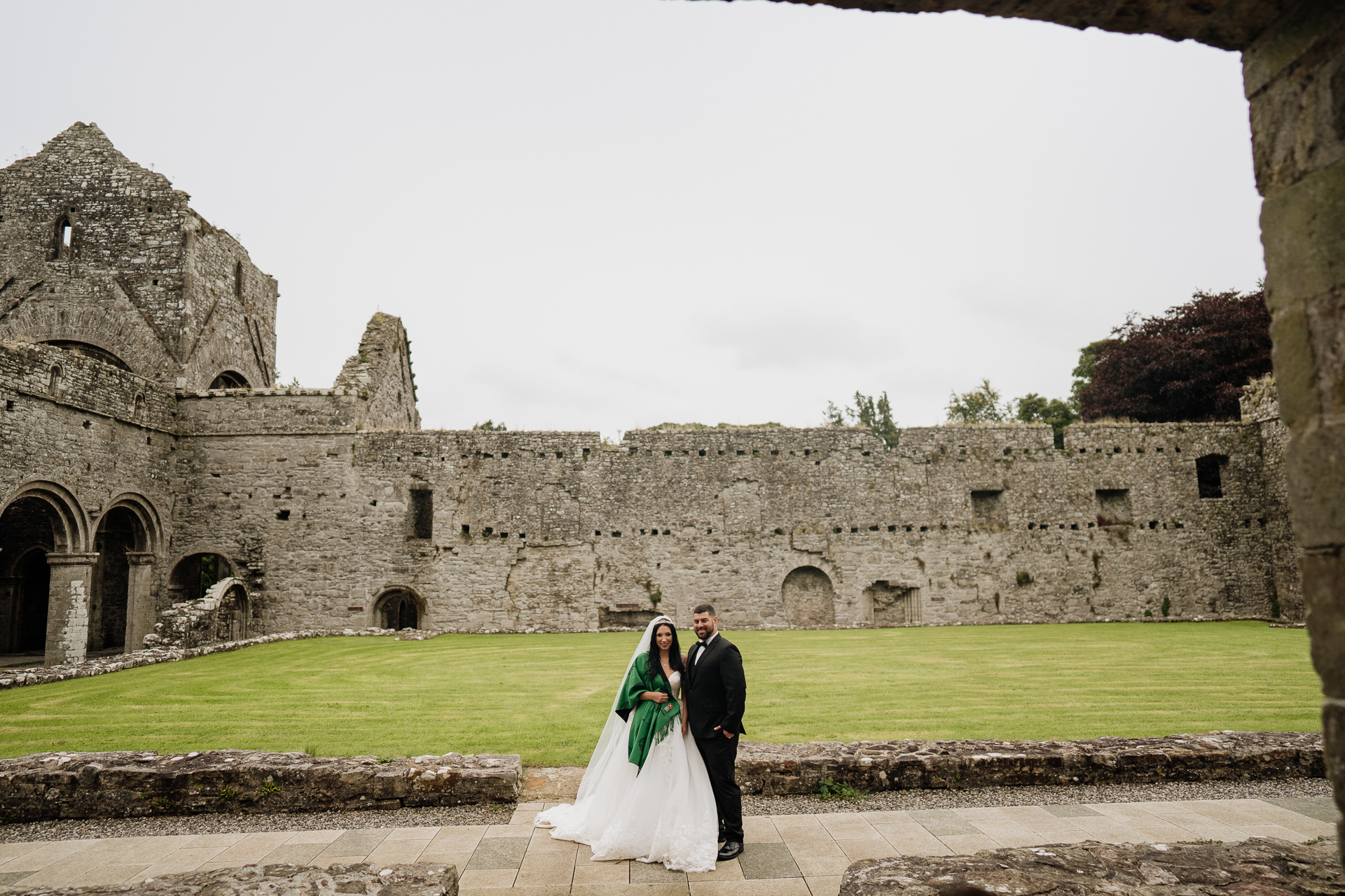 A man and woman in front of a stone building