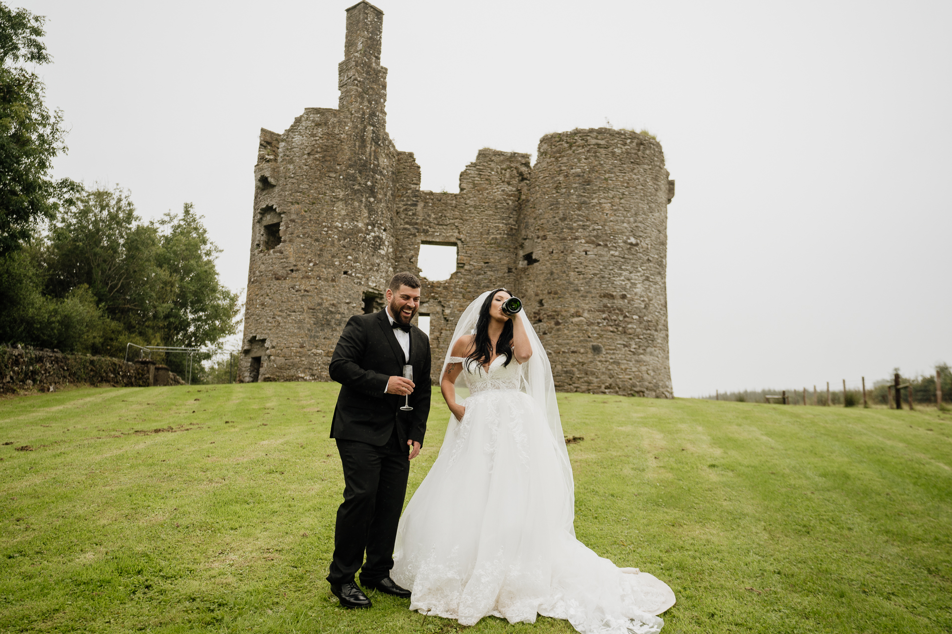 A man and woman posing in front of a castle