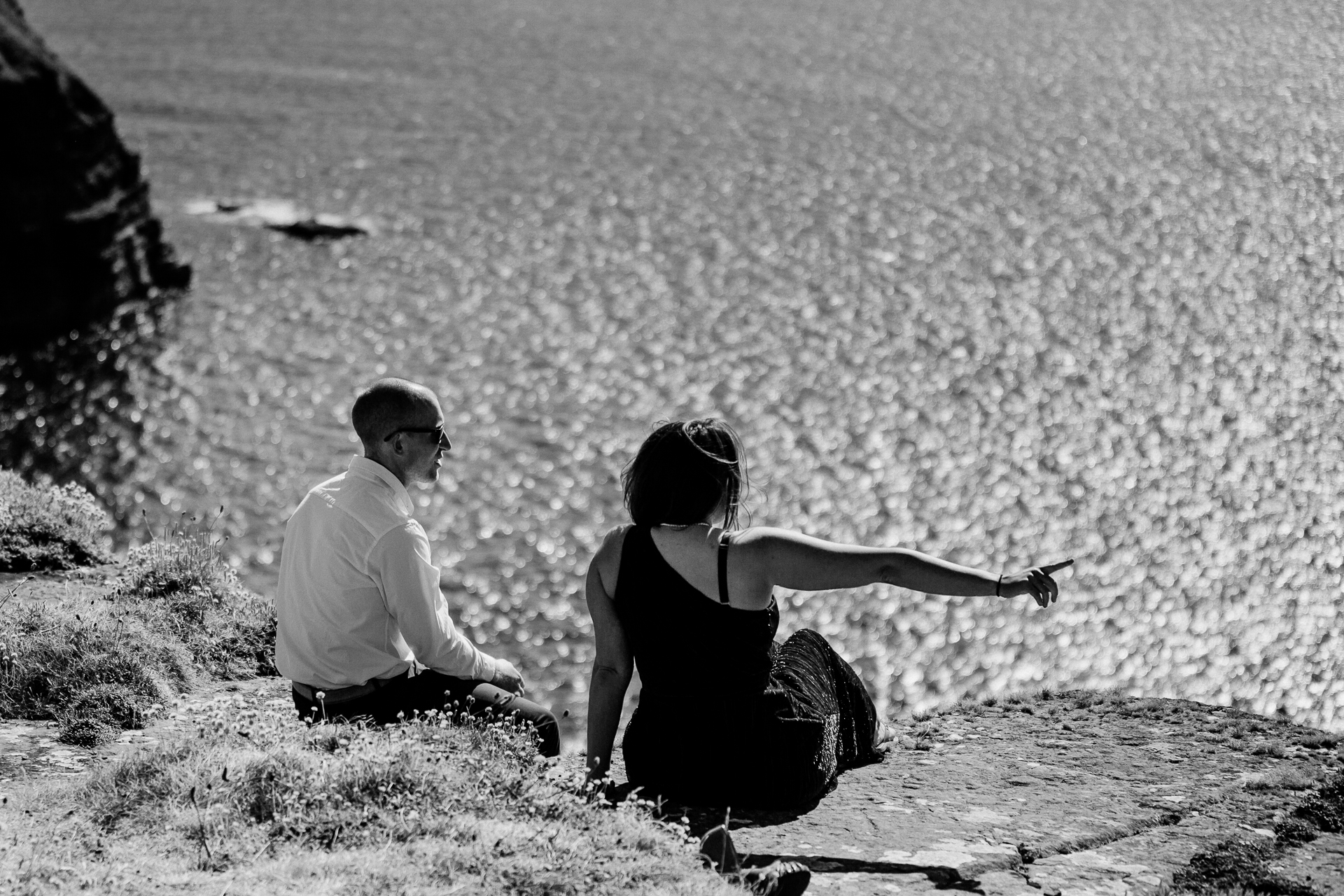 A man and woman sitting on a hill