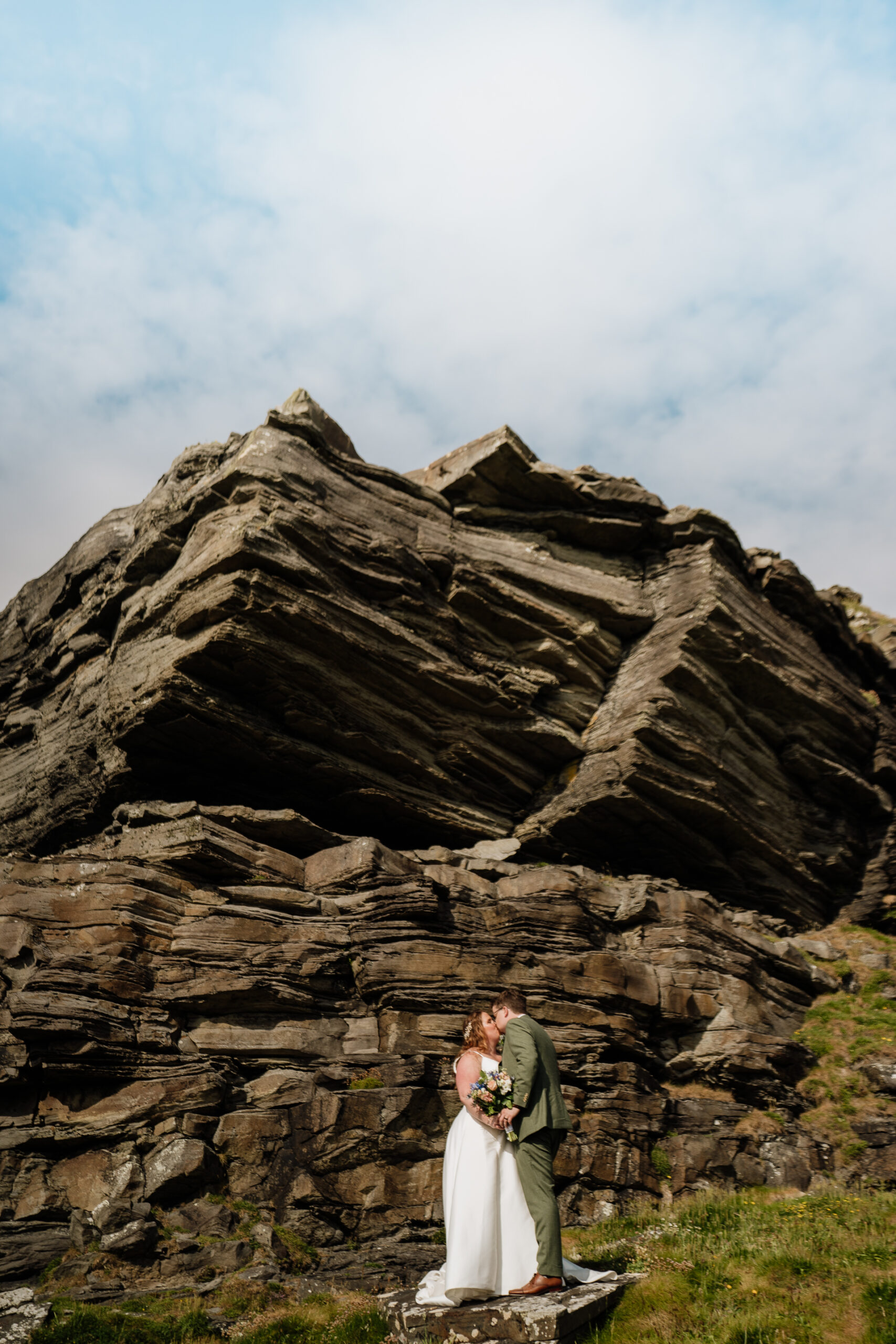 A man and woman in front of a large rock formation