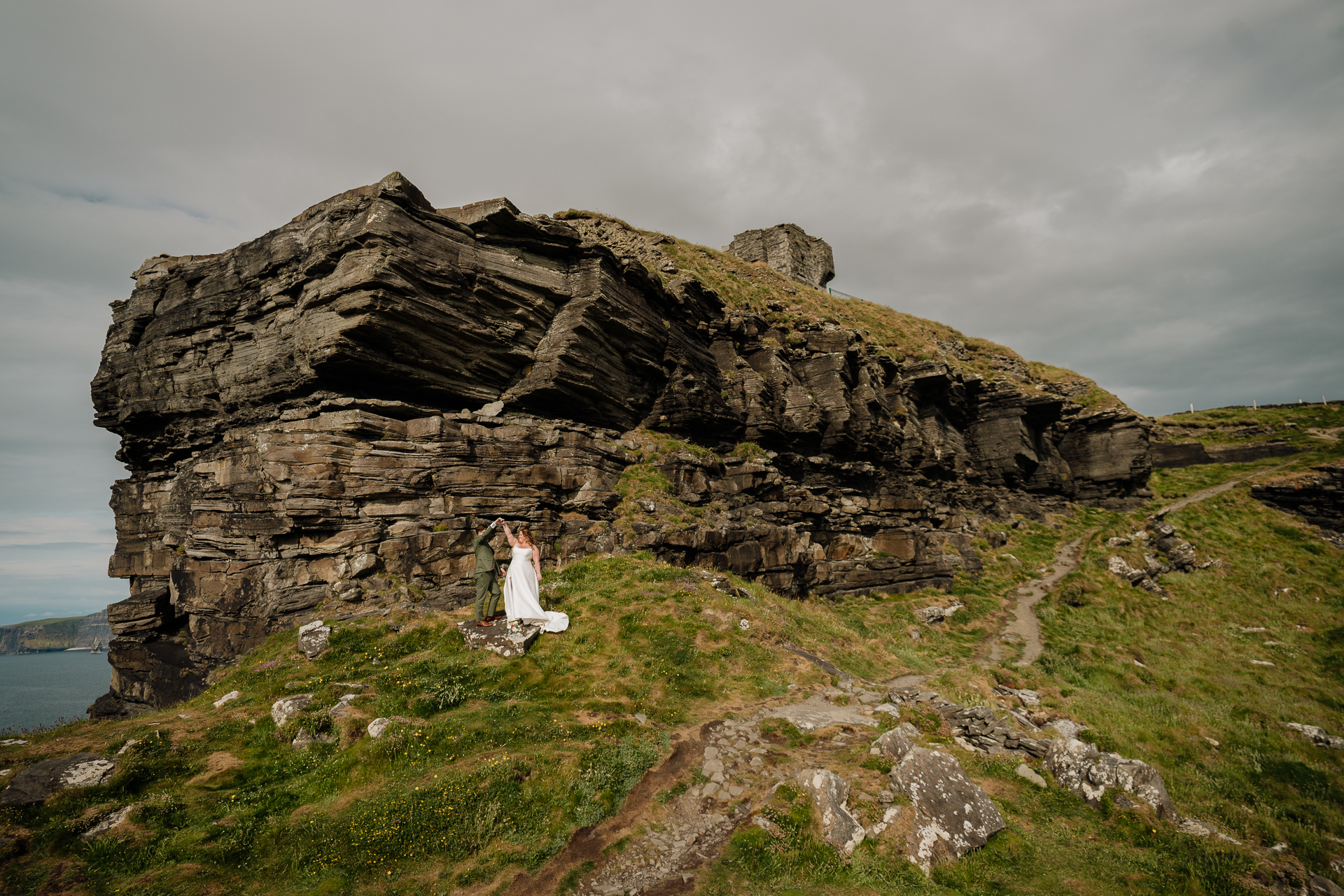 A couple people standing on a cliff