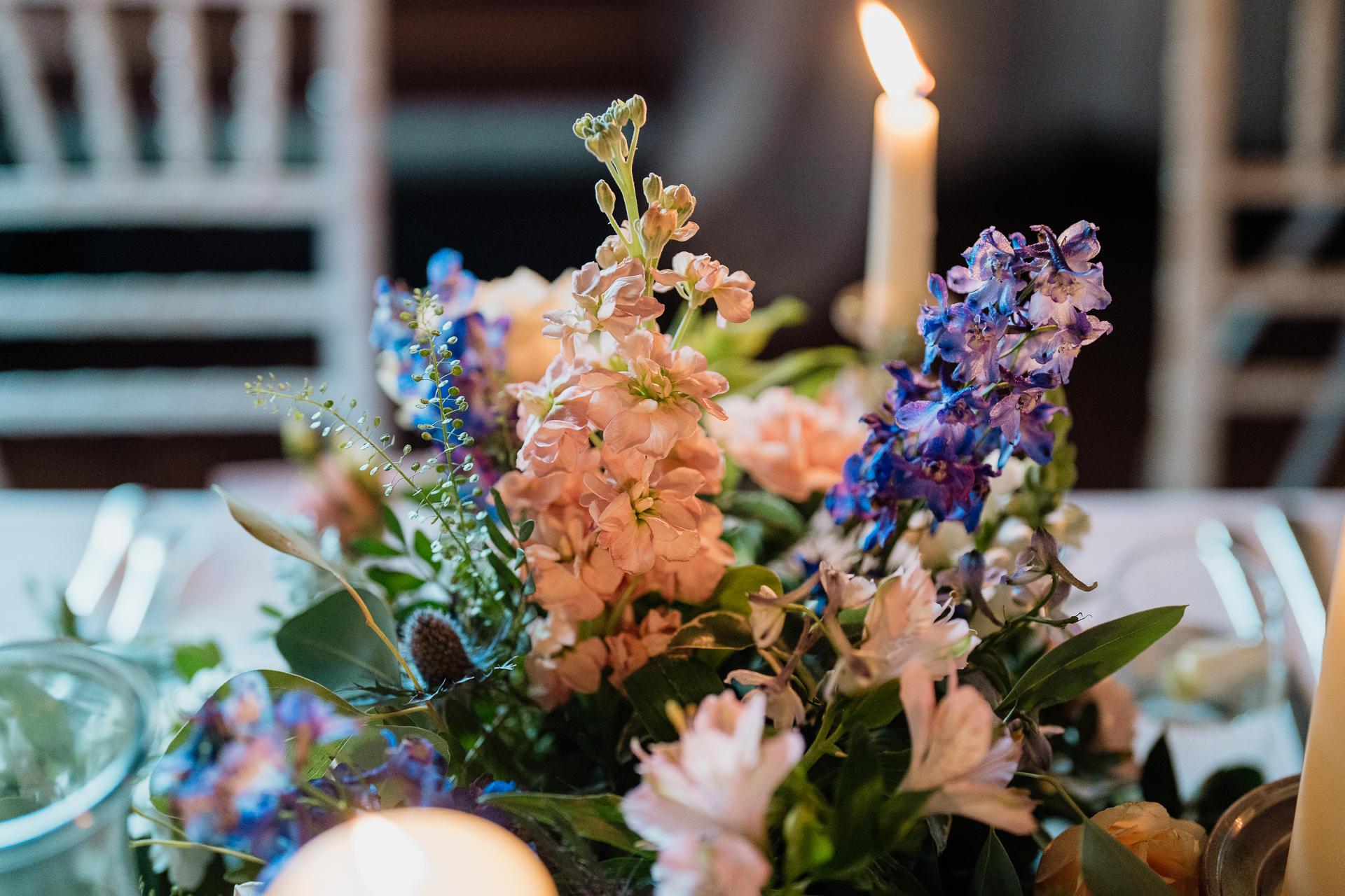 A candle in a bouquet of flowers