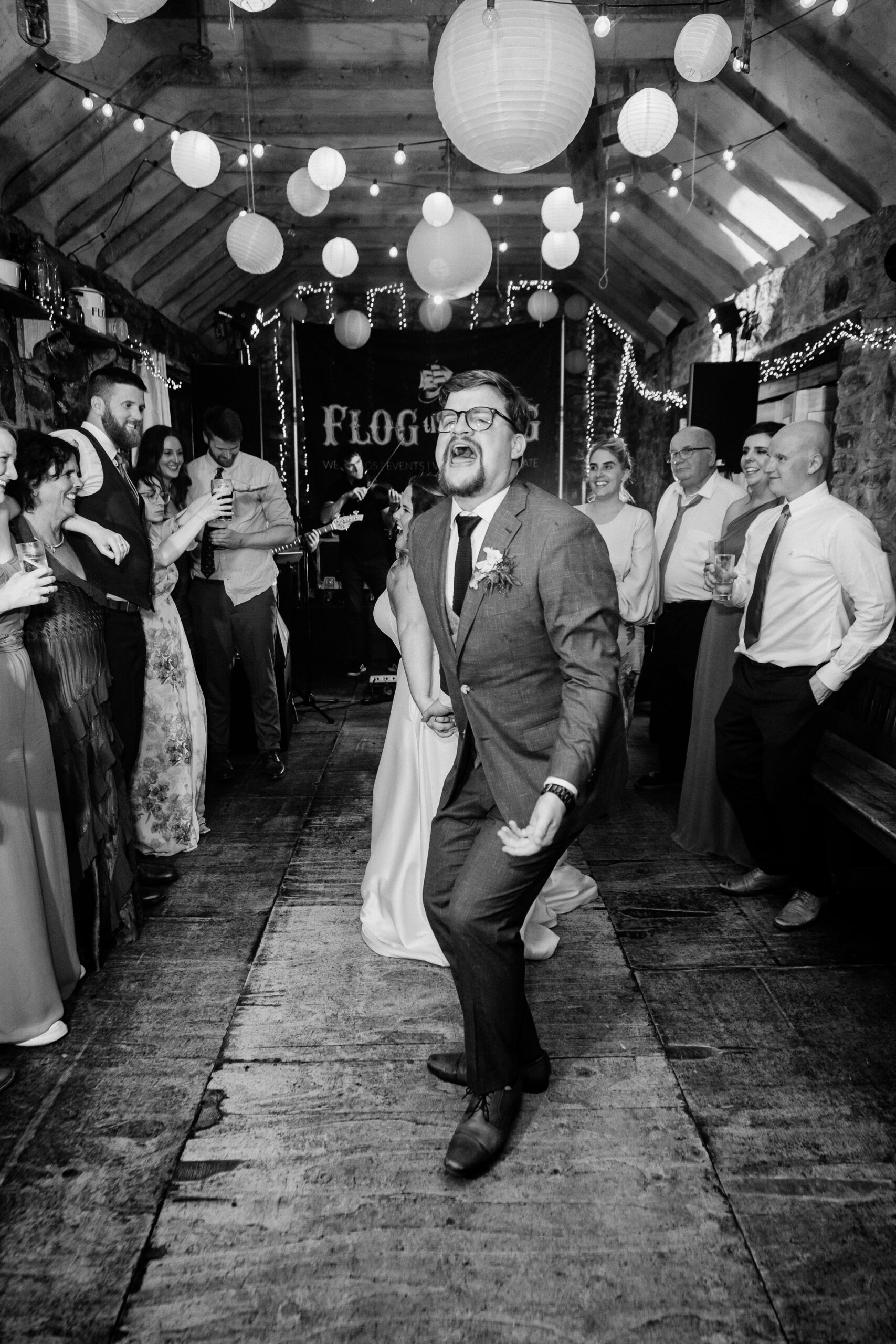 A person in a suit walking down a hall with a crowd of people