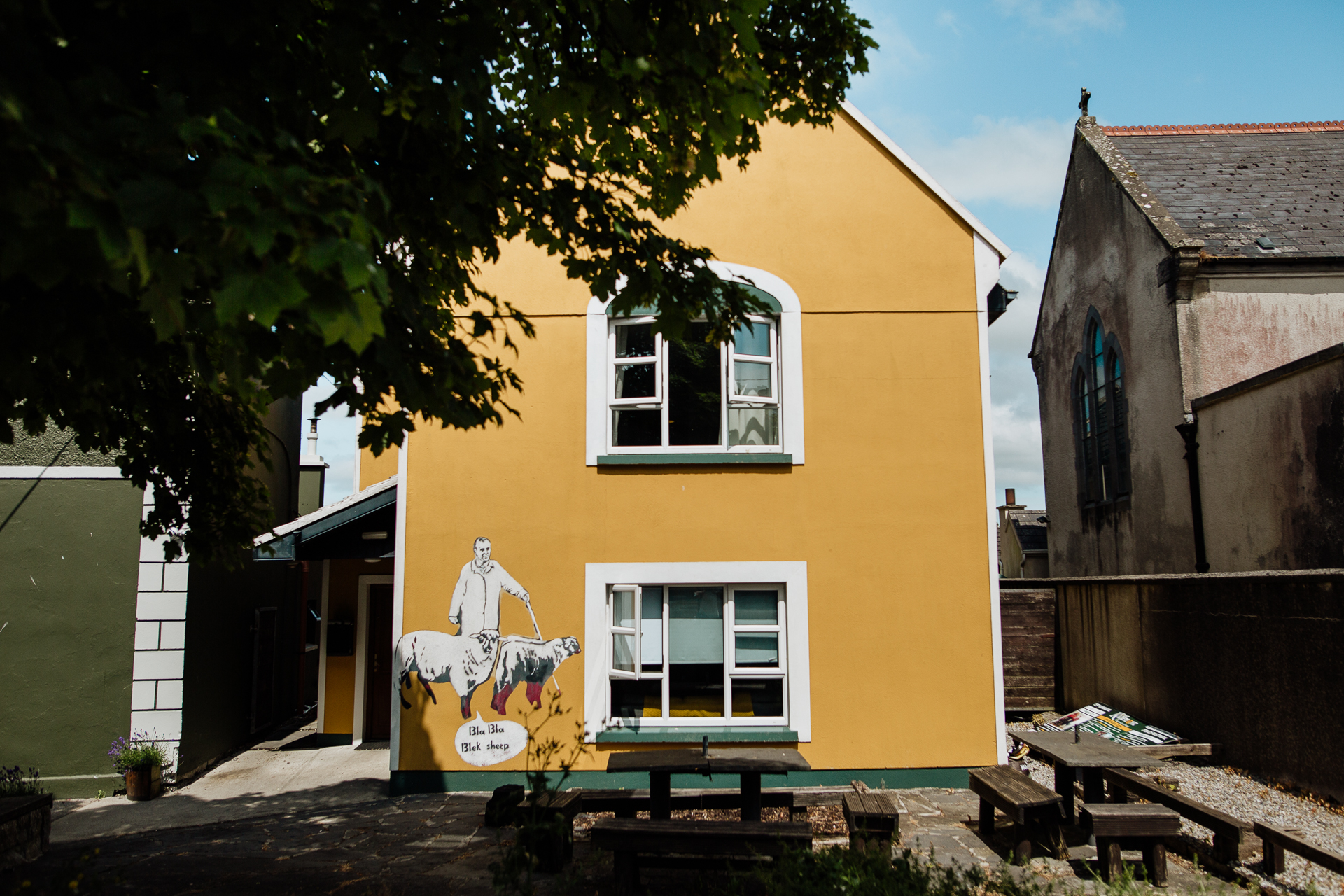 A yellow building with a tree in front of it