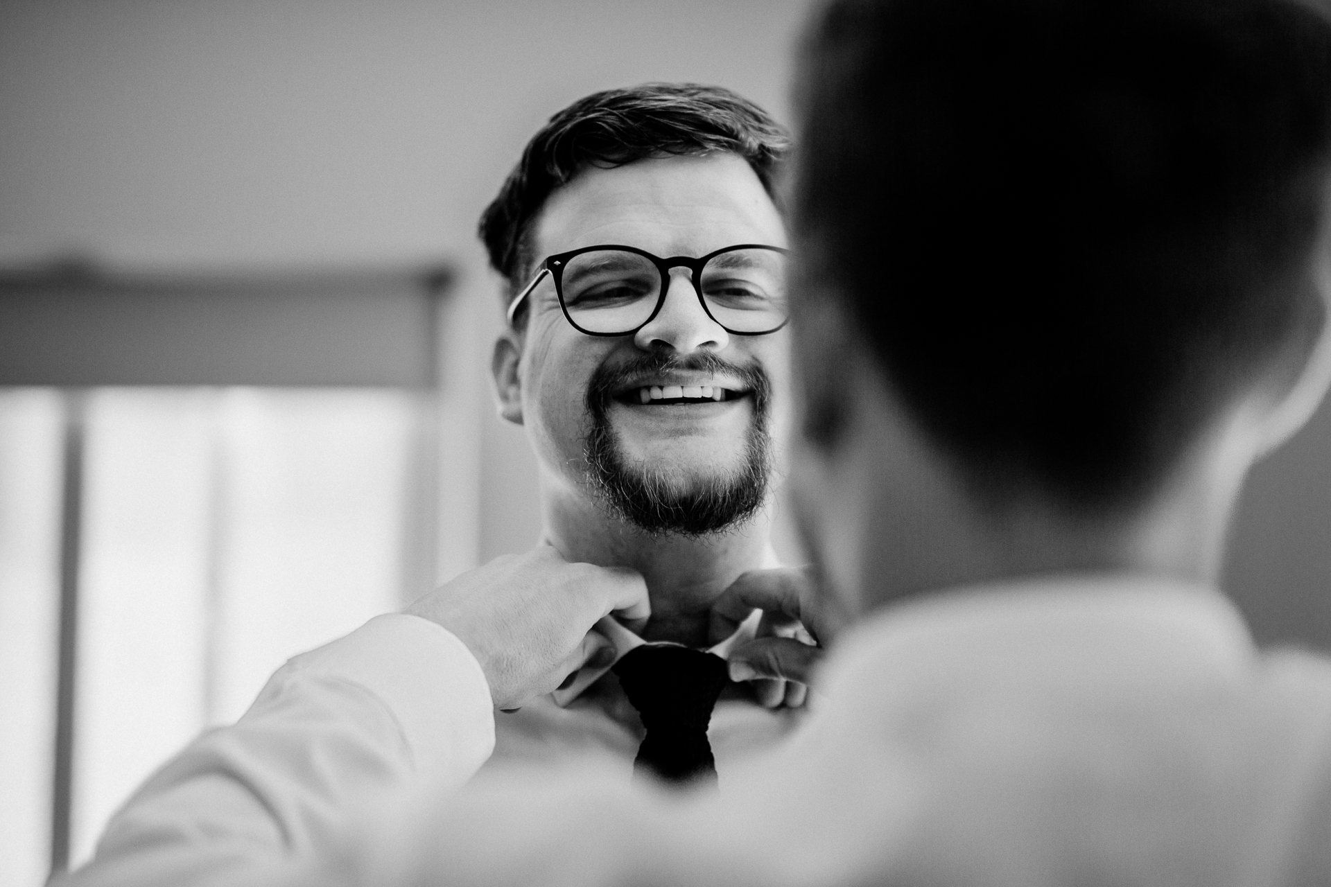 A man with glasses smiling