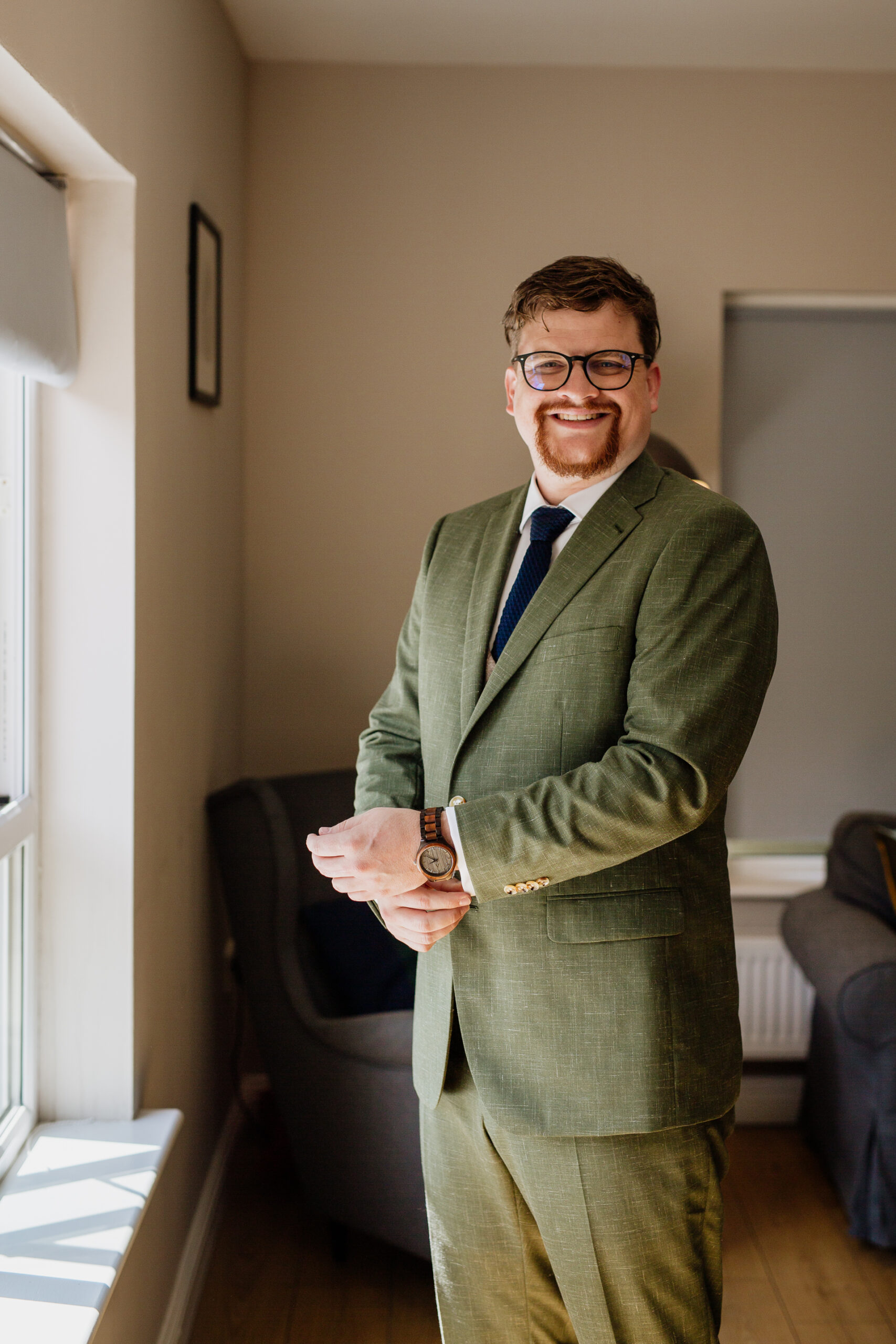 A man in a suit holding a bottle of alcohol