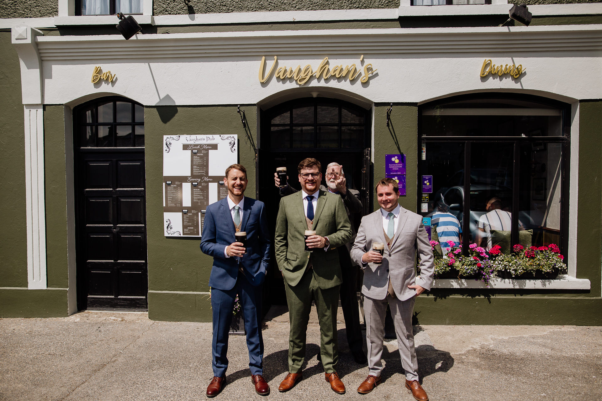 A group of men posing for a picture in front of a building