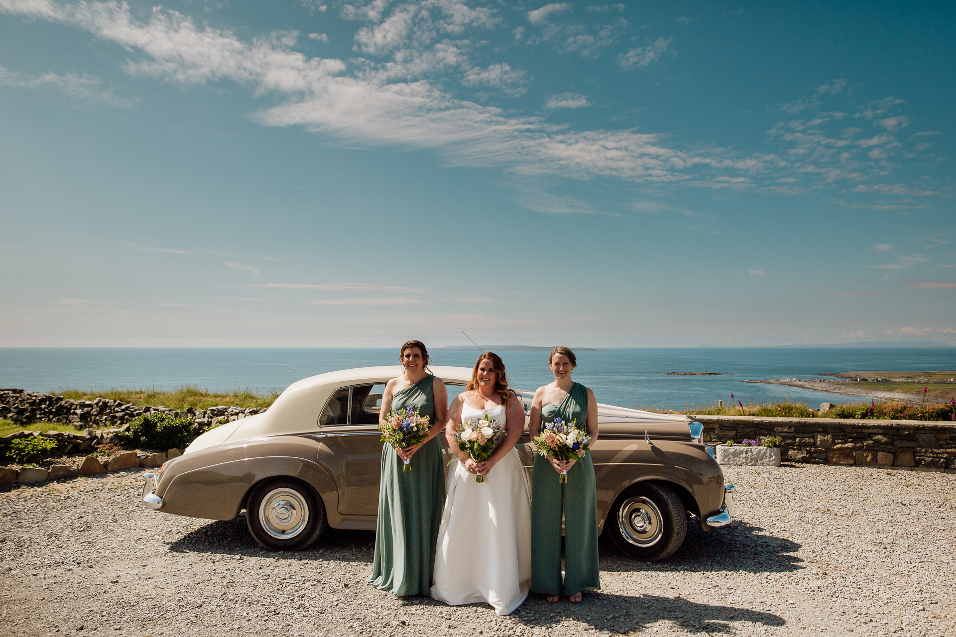 A group of people posing for the camera next to a car