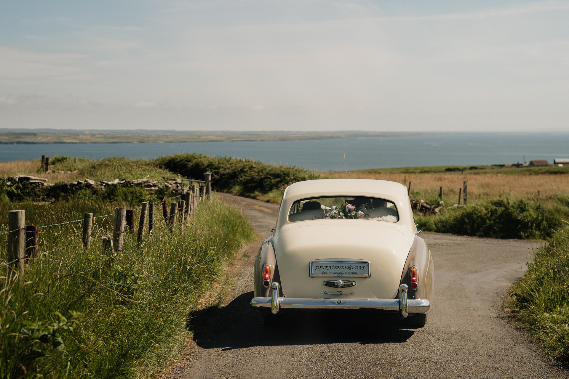 A car parked on a road near a body of water