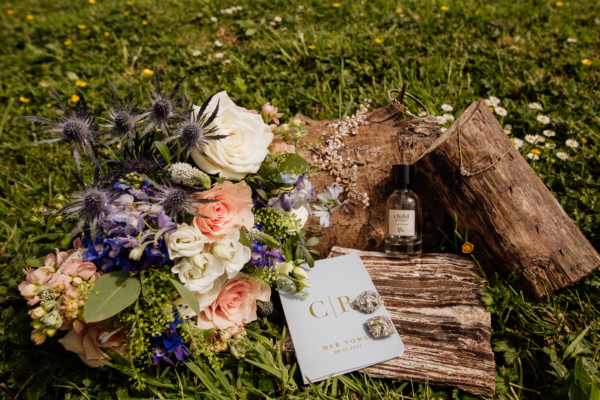 A bouquet of flowers and a bottle of wine on a wood table