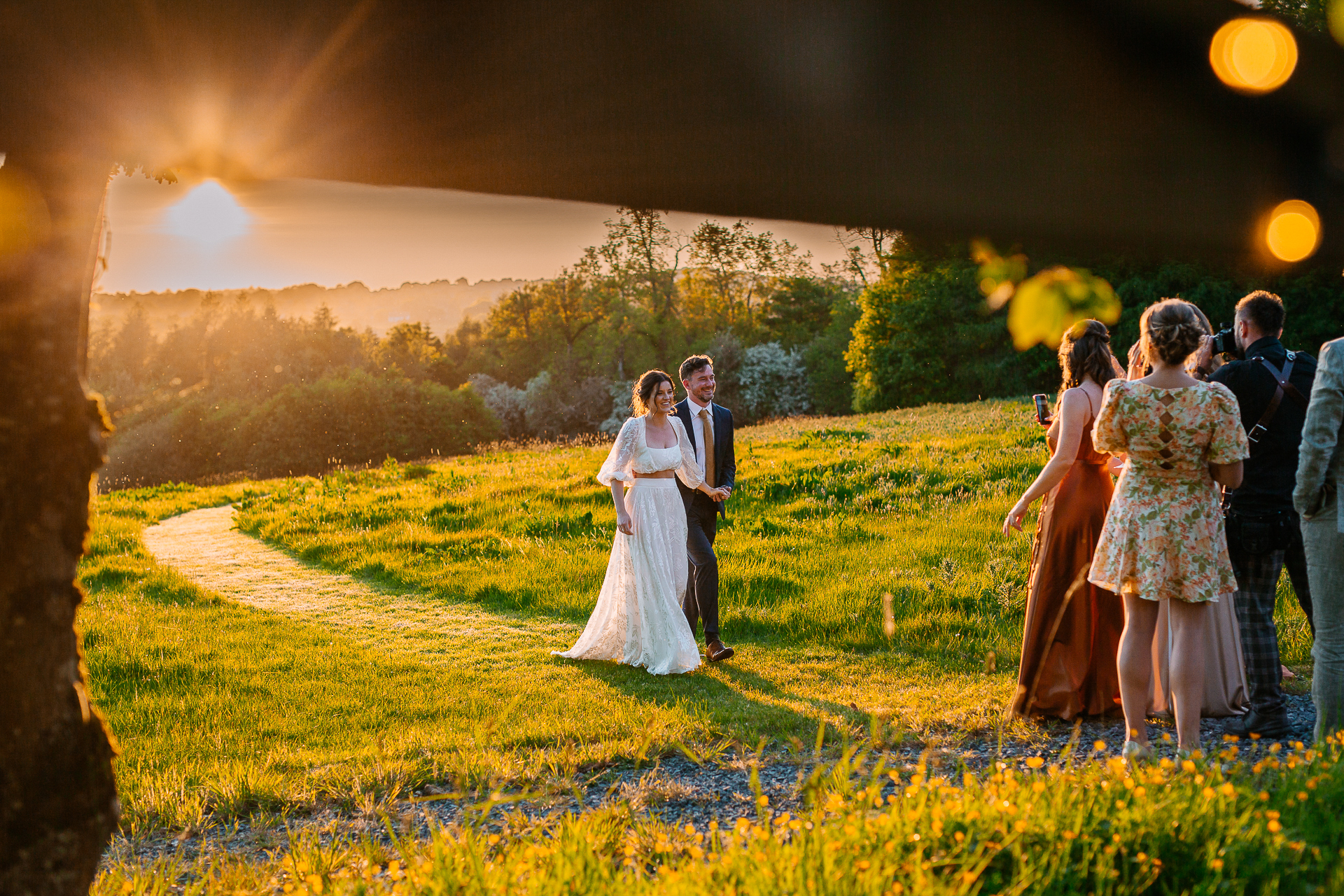 A group of people standing in a field with flowers and grass