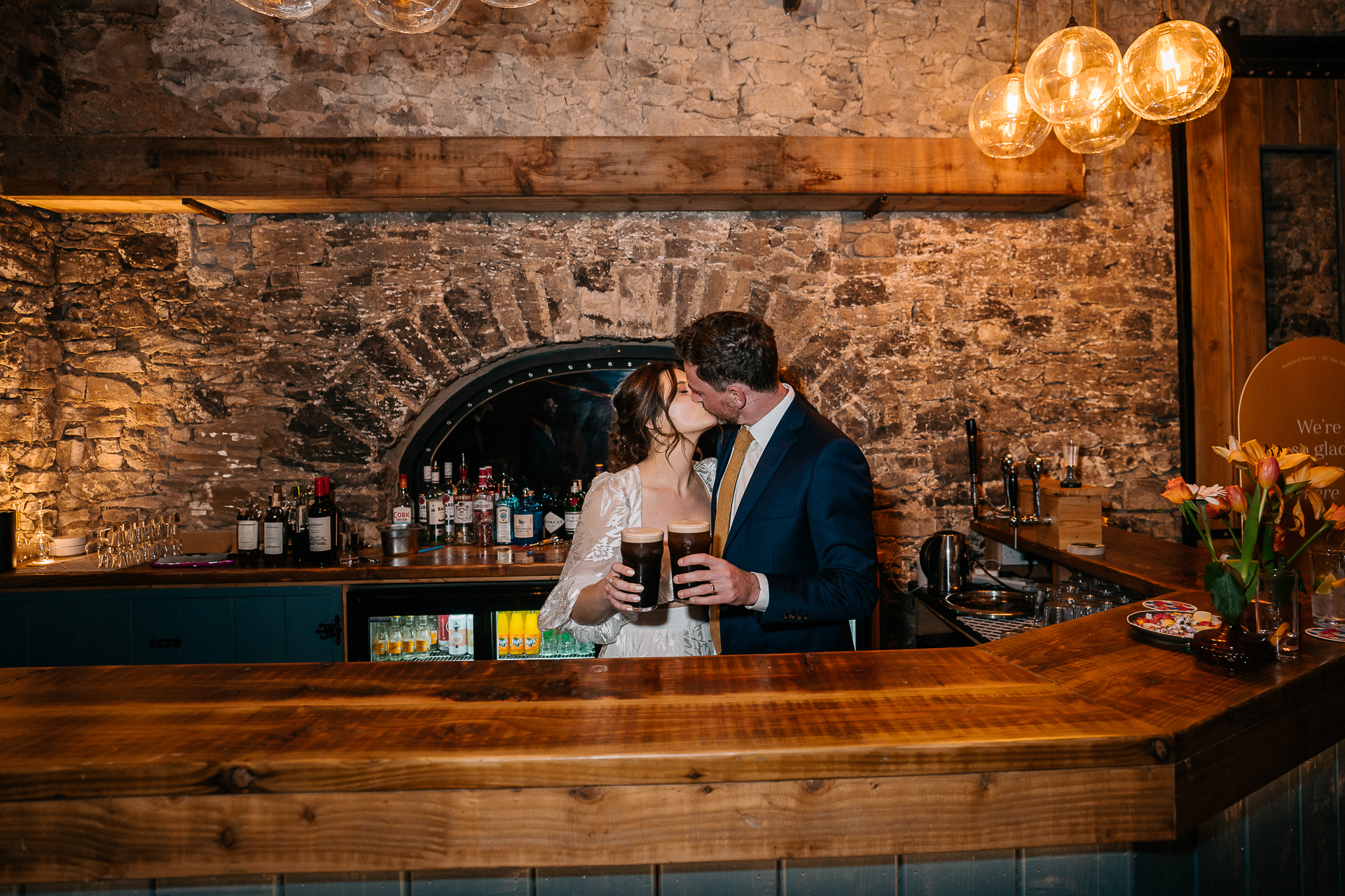 A man and woman kissing at a bar