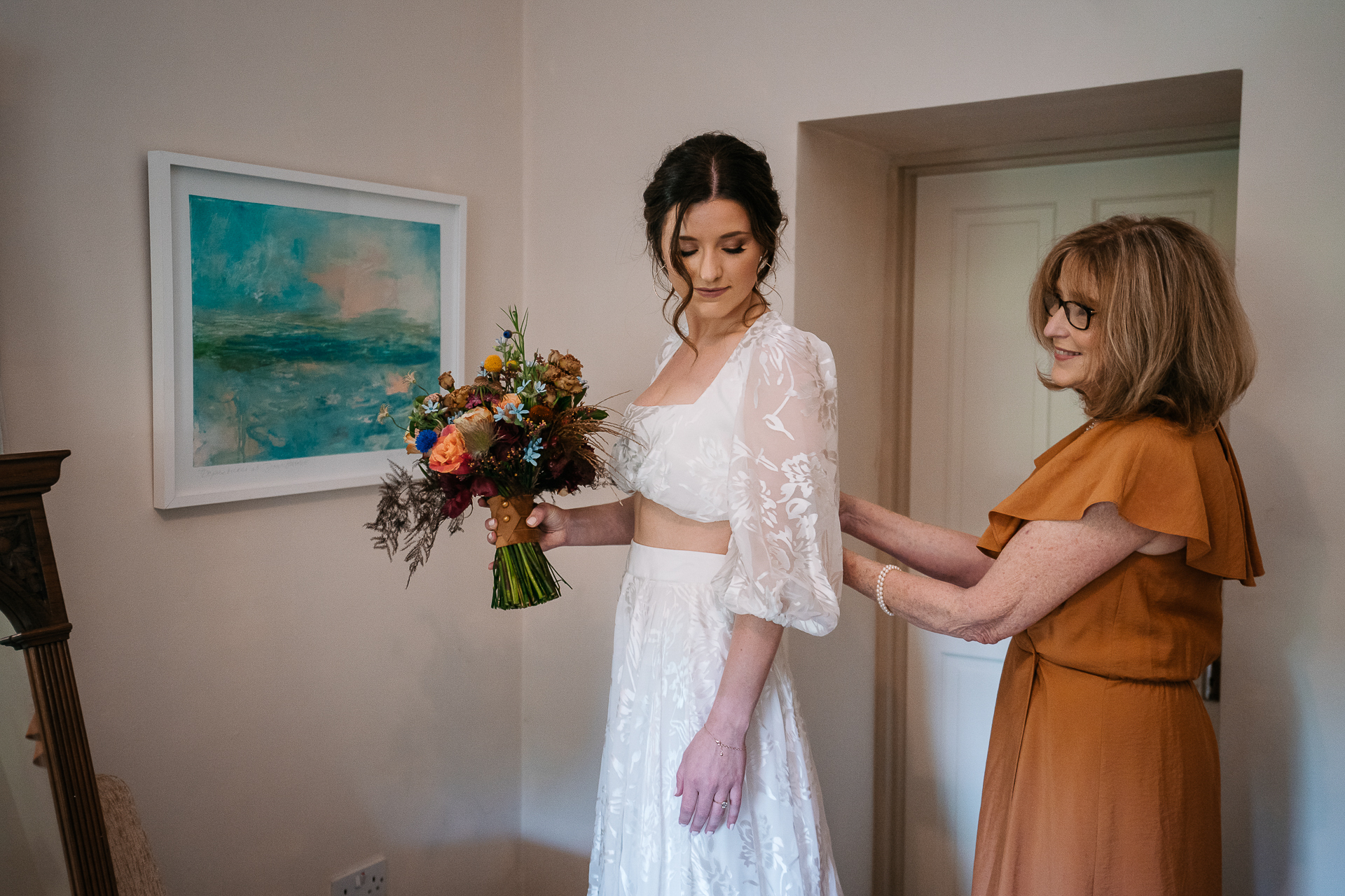 A person in a white dress holding a bouquet of flowers next to a person in a white dress