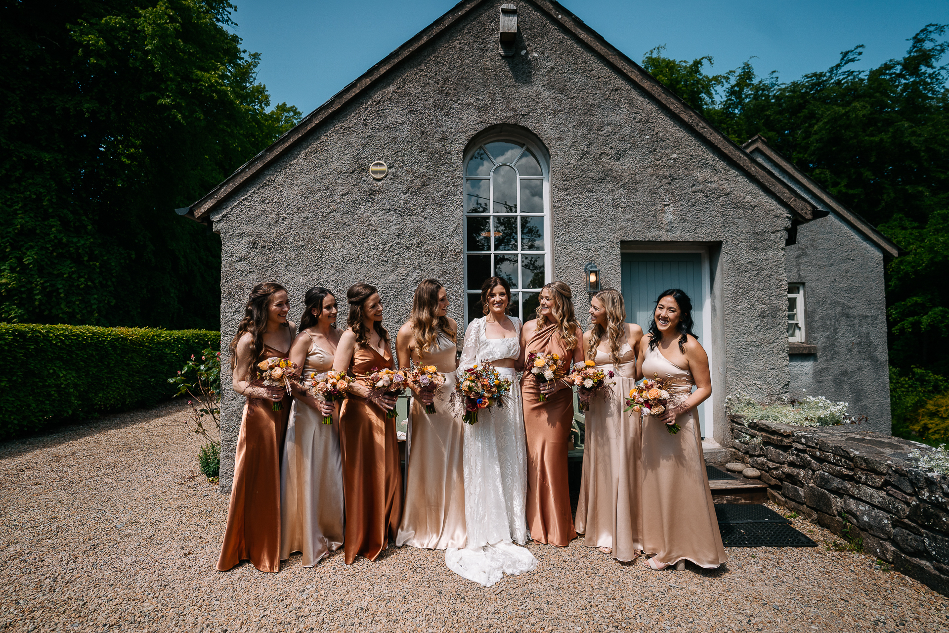 A group of women in dresses posing for a photo outside a house