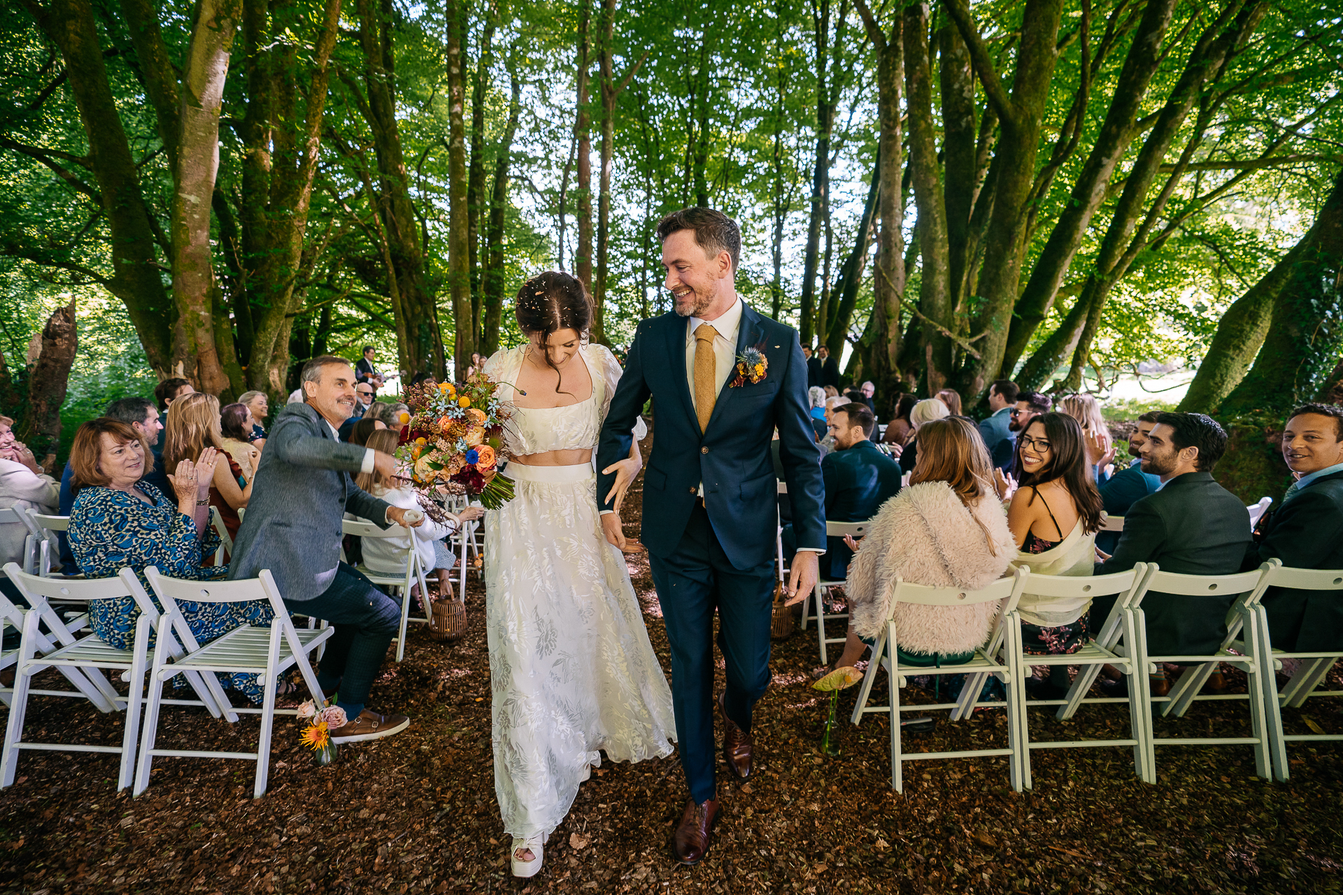 A man and woman walking down a aisle in front of a crowd