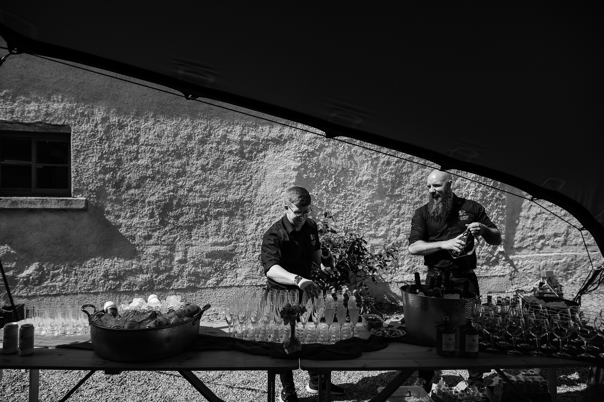 A couple of men sitting at a table with food and drinks