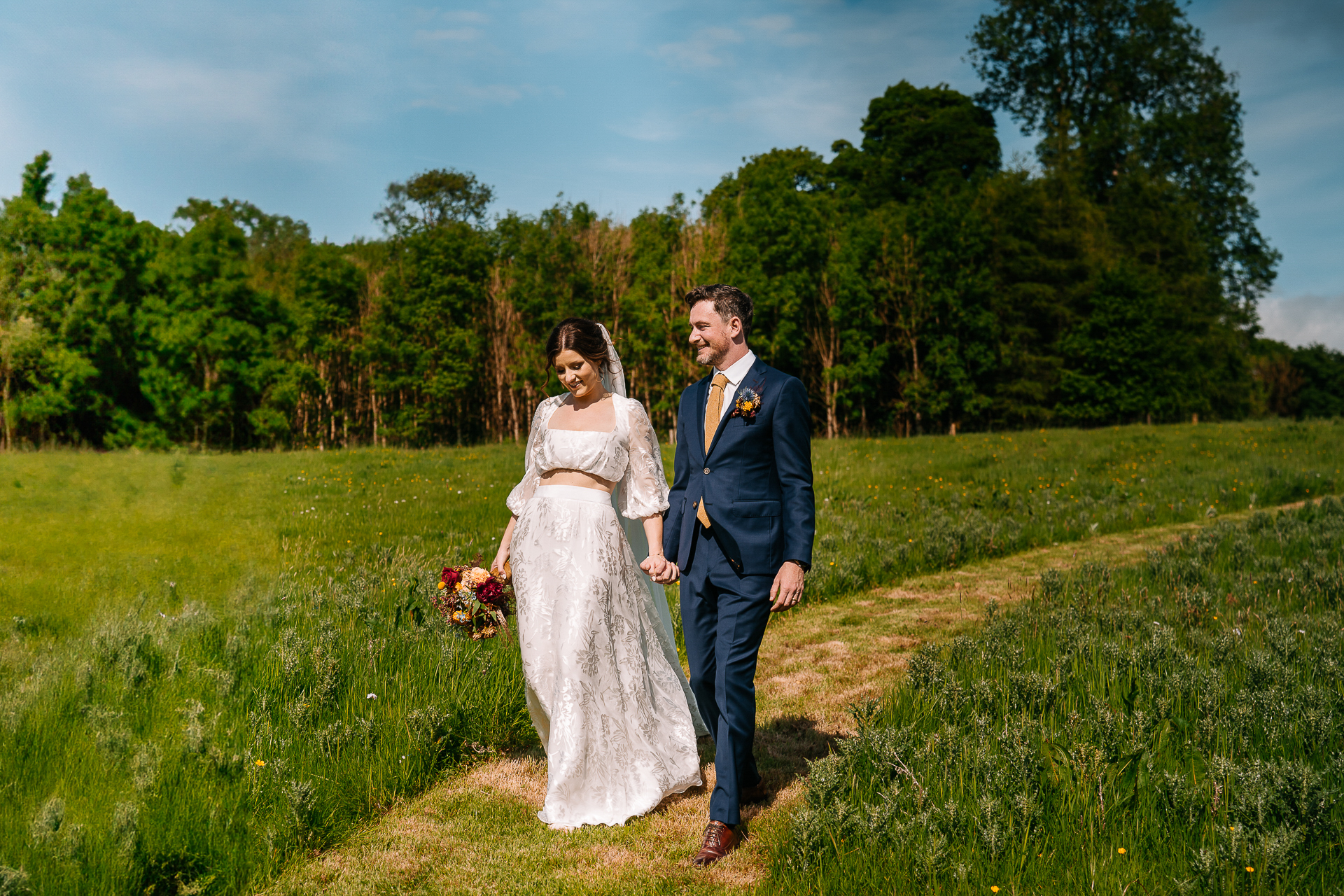 A man and woman posing for a picture in a field