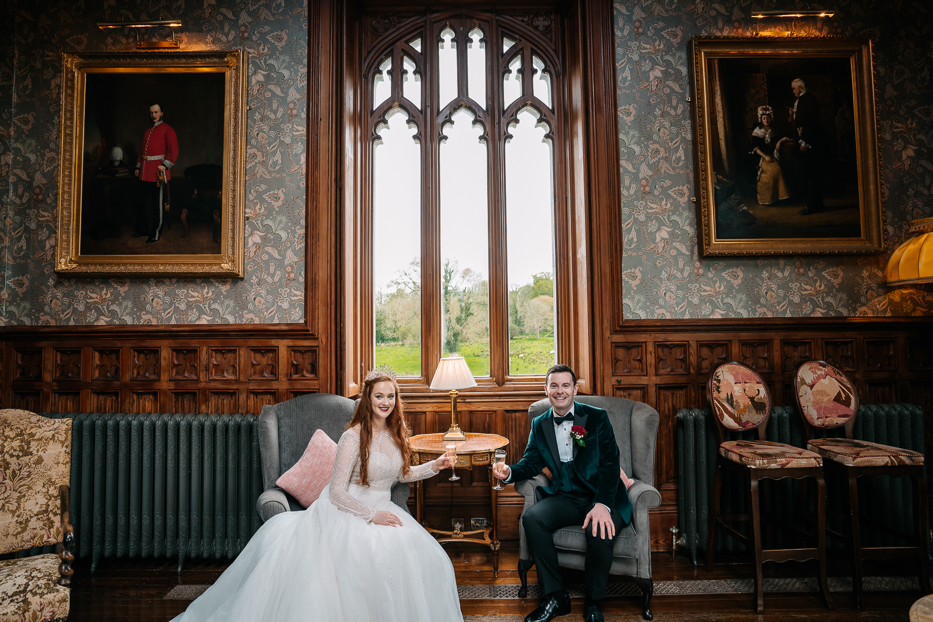 A bride and groom sitting in a room with a large window