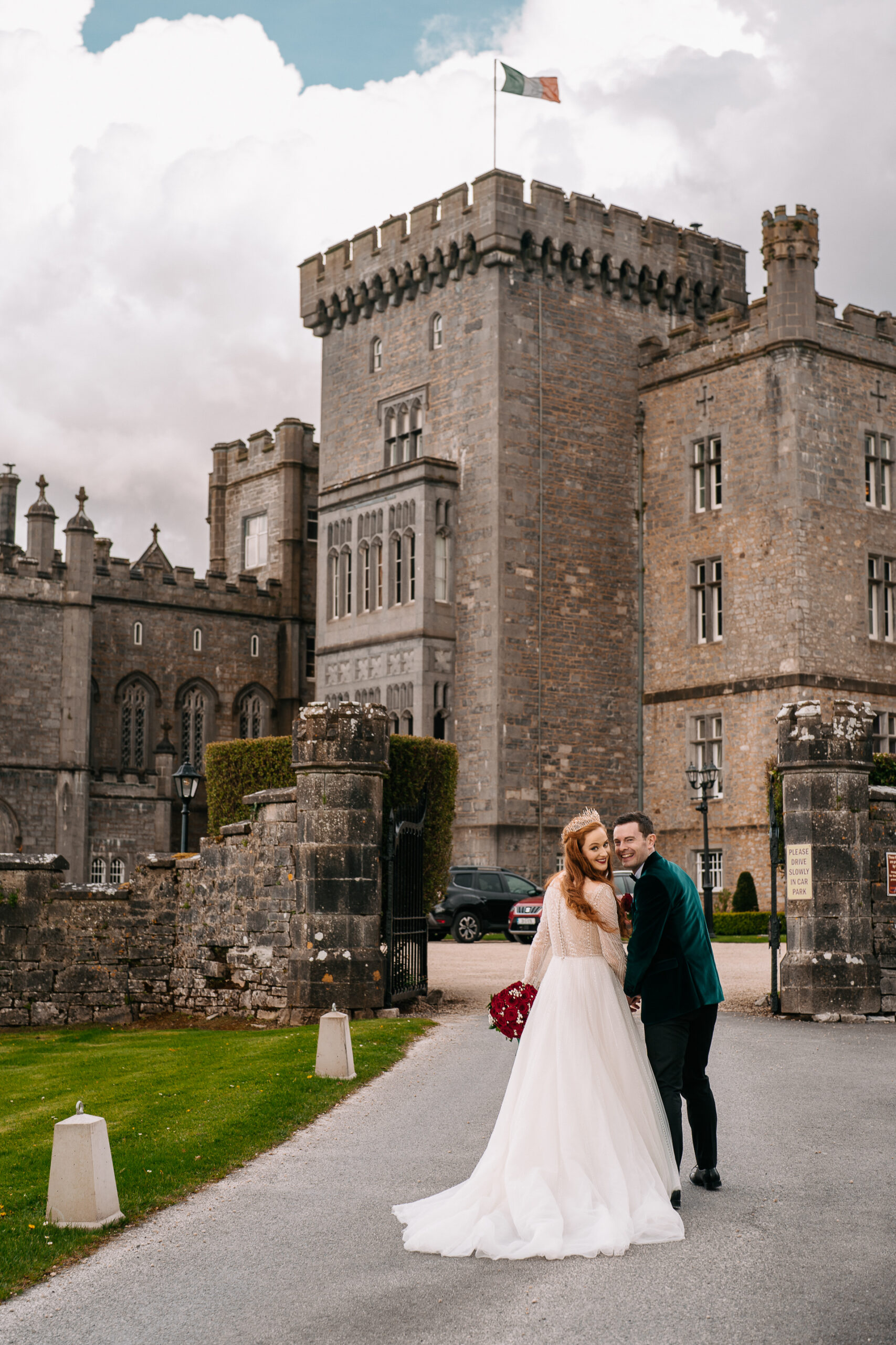 A man and woman walking down a road in front of a castle