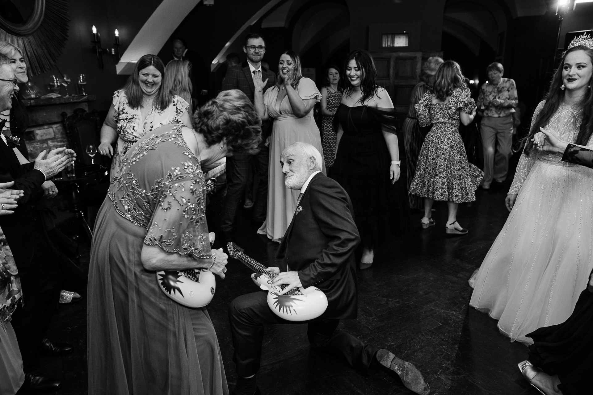 A man and woman dancing in a room with a group of people