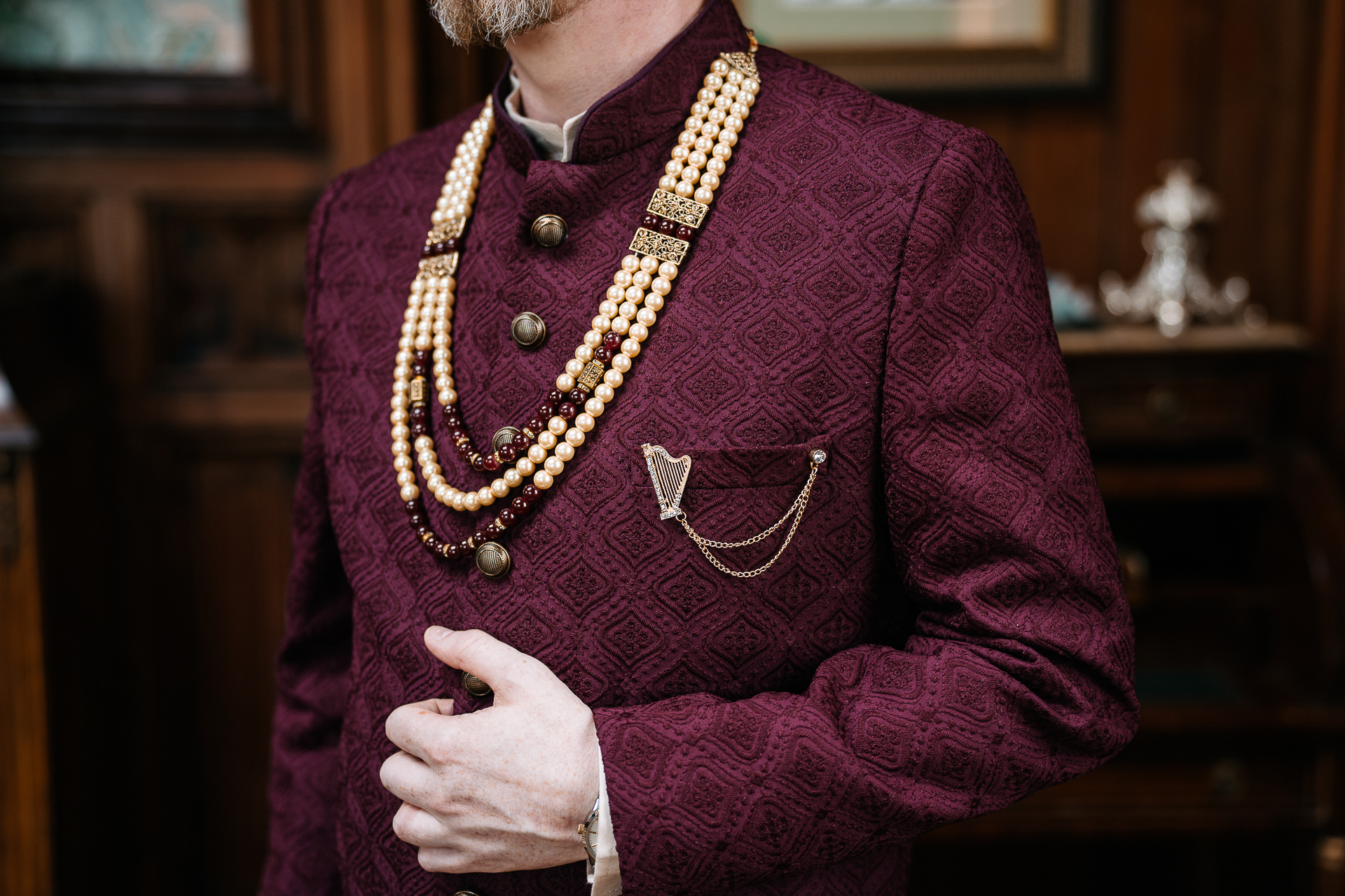 A person wearing a red robe and gold necklace