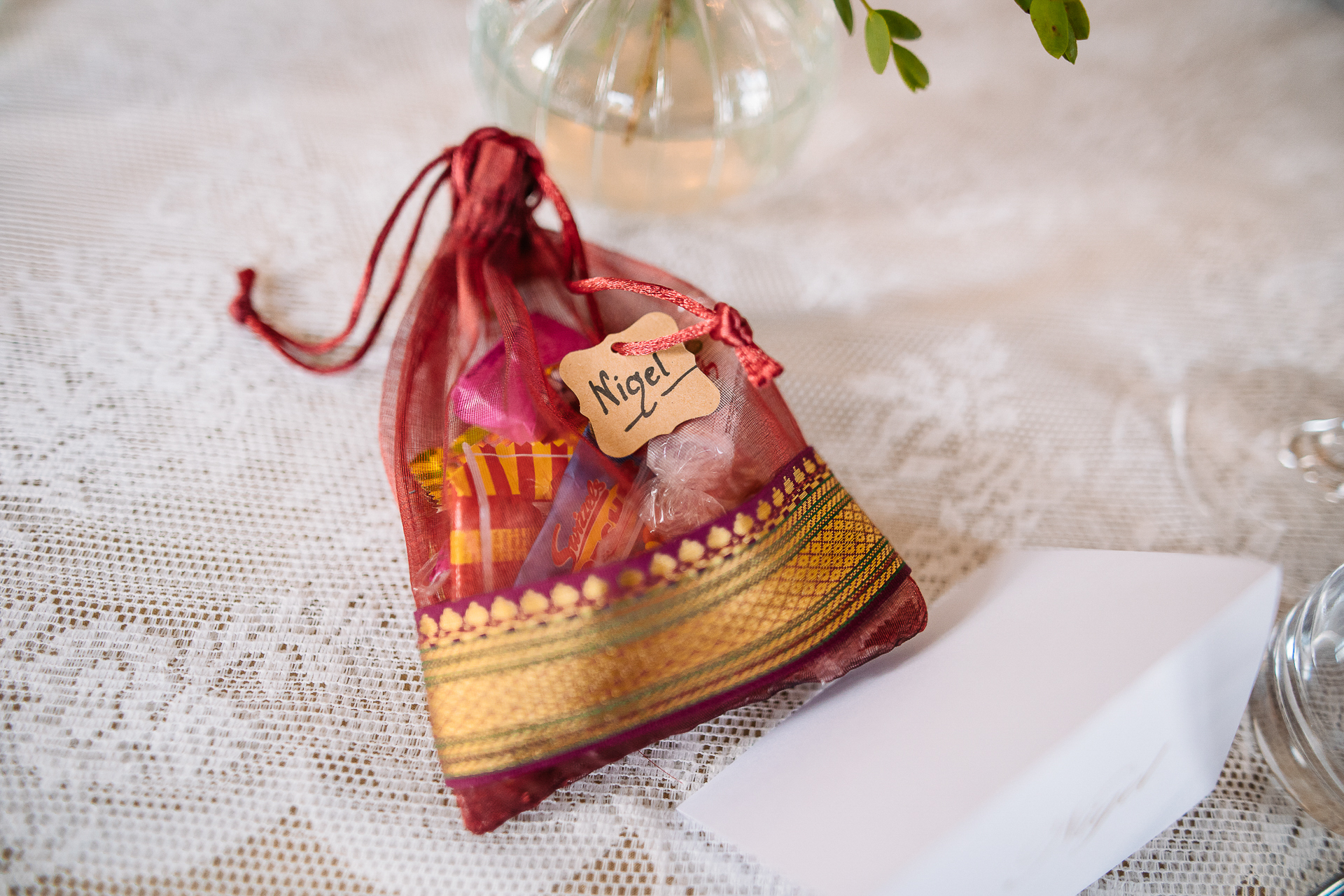 A wrapped gift wrapped in a red ribbon on a white tablecloth