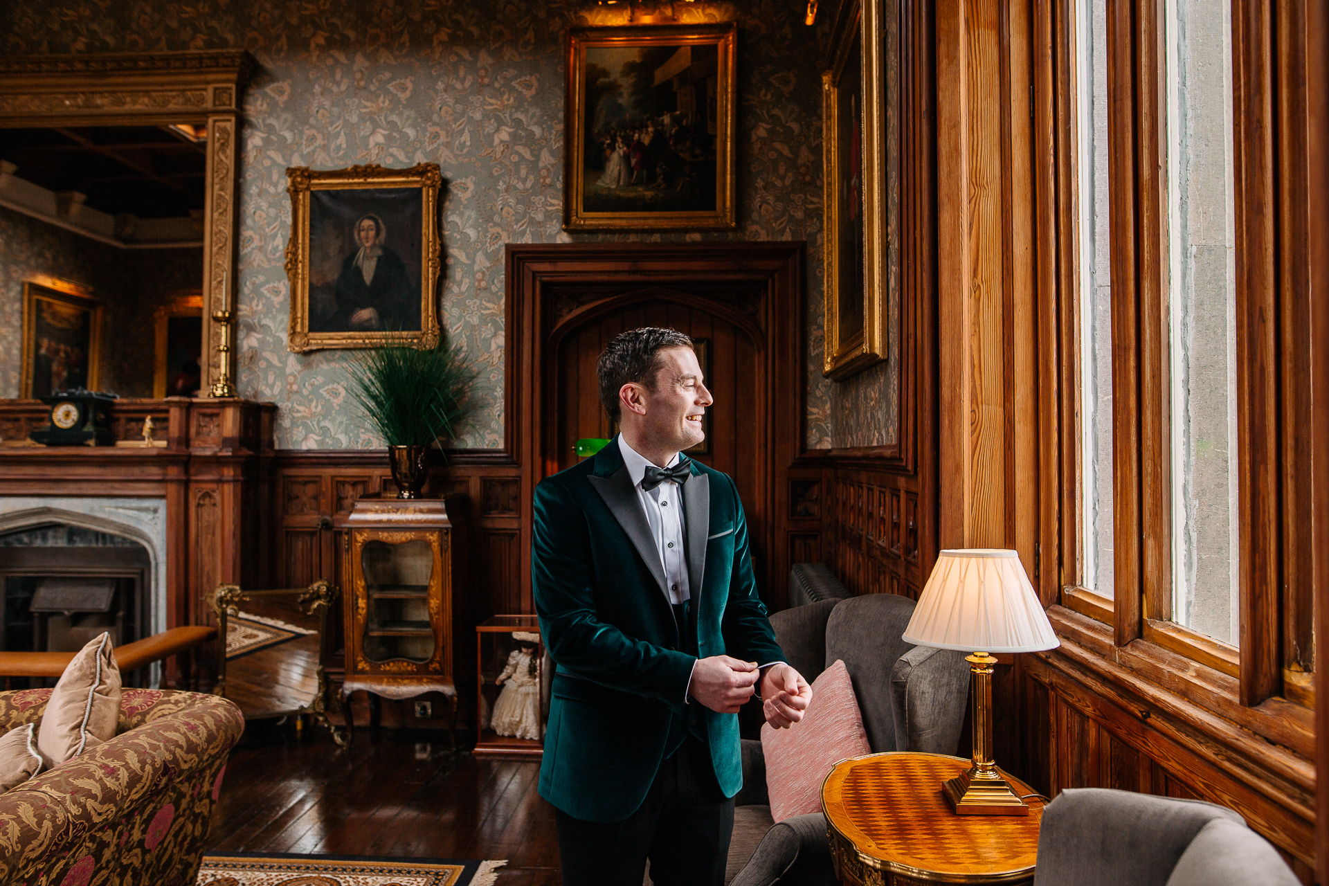 A person in a suit in a room with a fireplace