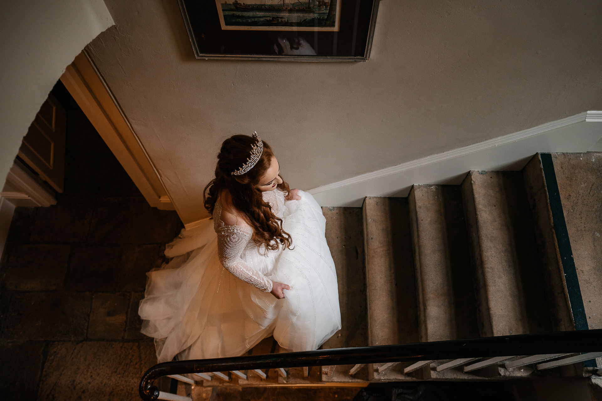 A person in a white dress and tiara on a staircase