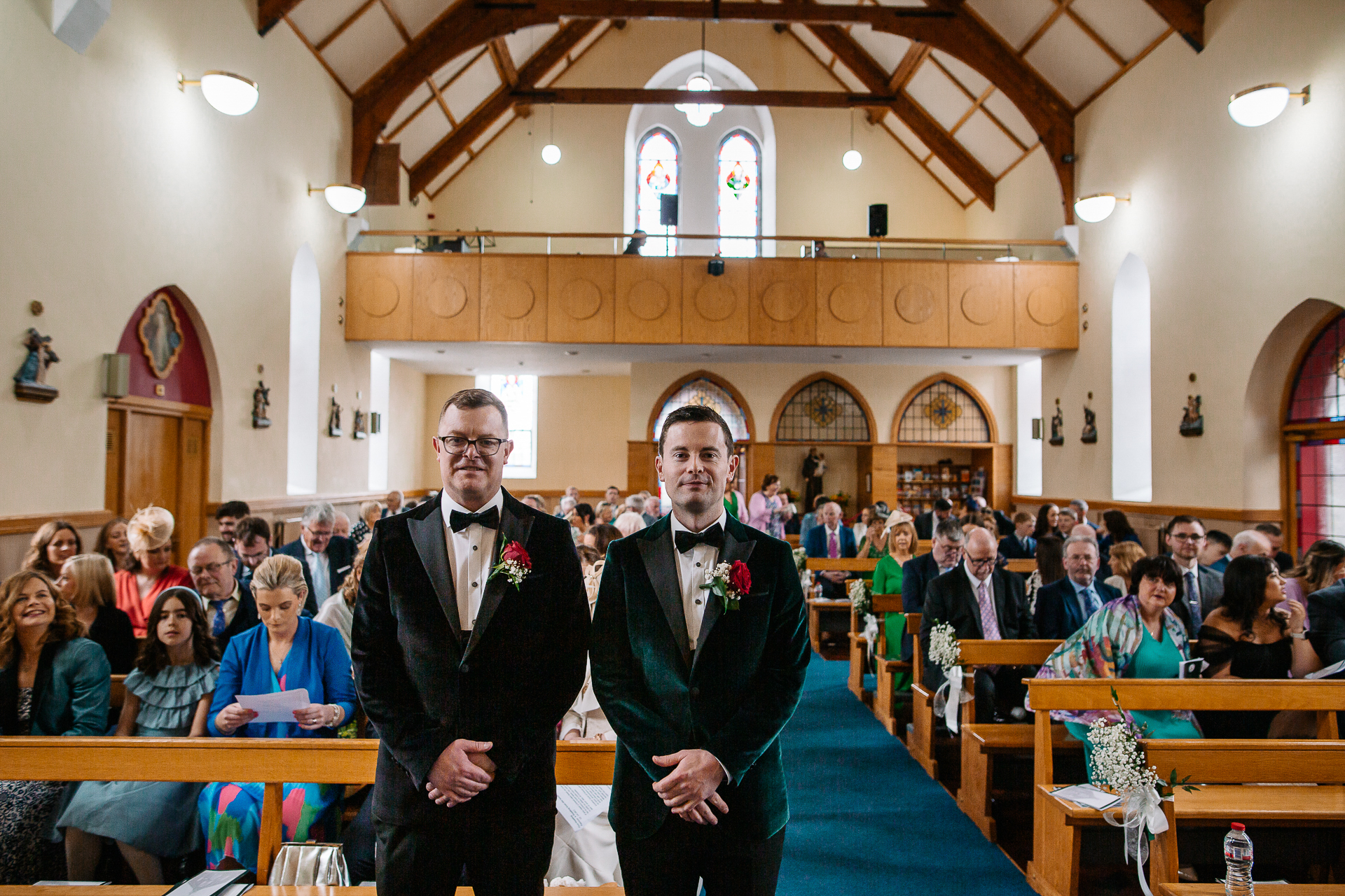 A couple of men in suits standing in front of a crowd of people