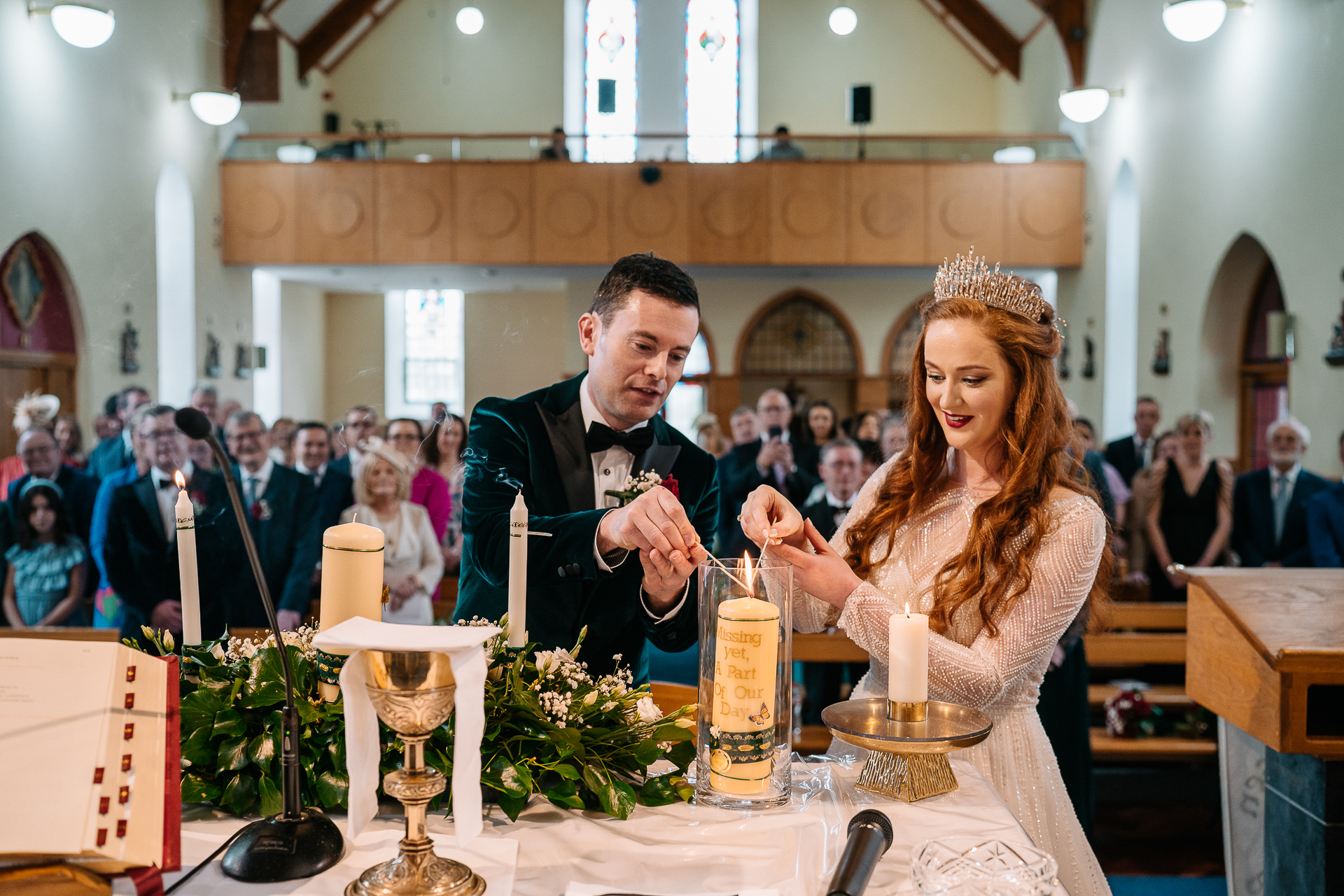 A man and woman sitting at a table with candles and flowers