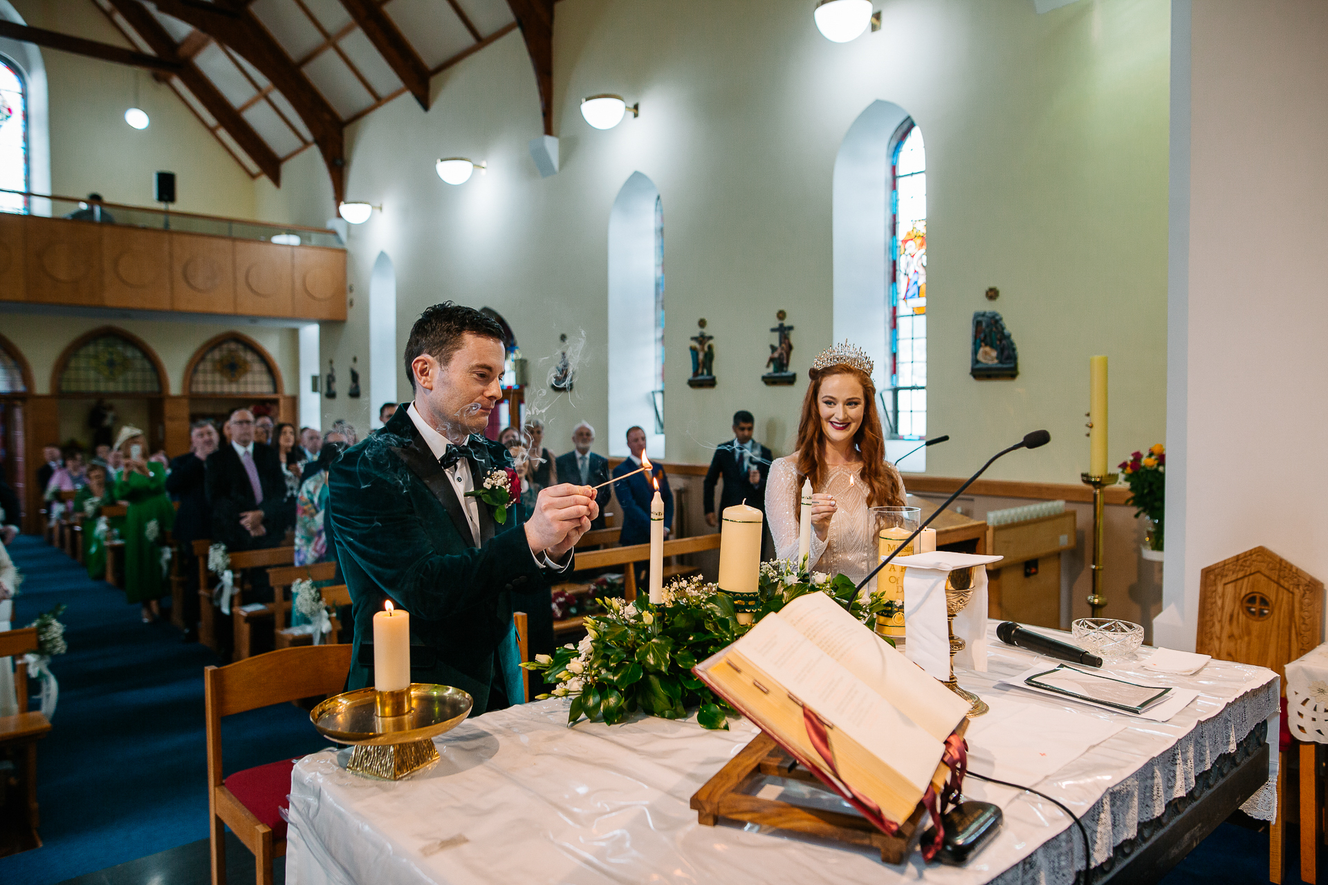 A man and woman sitting at a table with a book and a candle