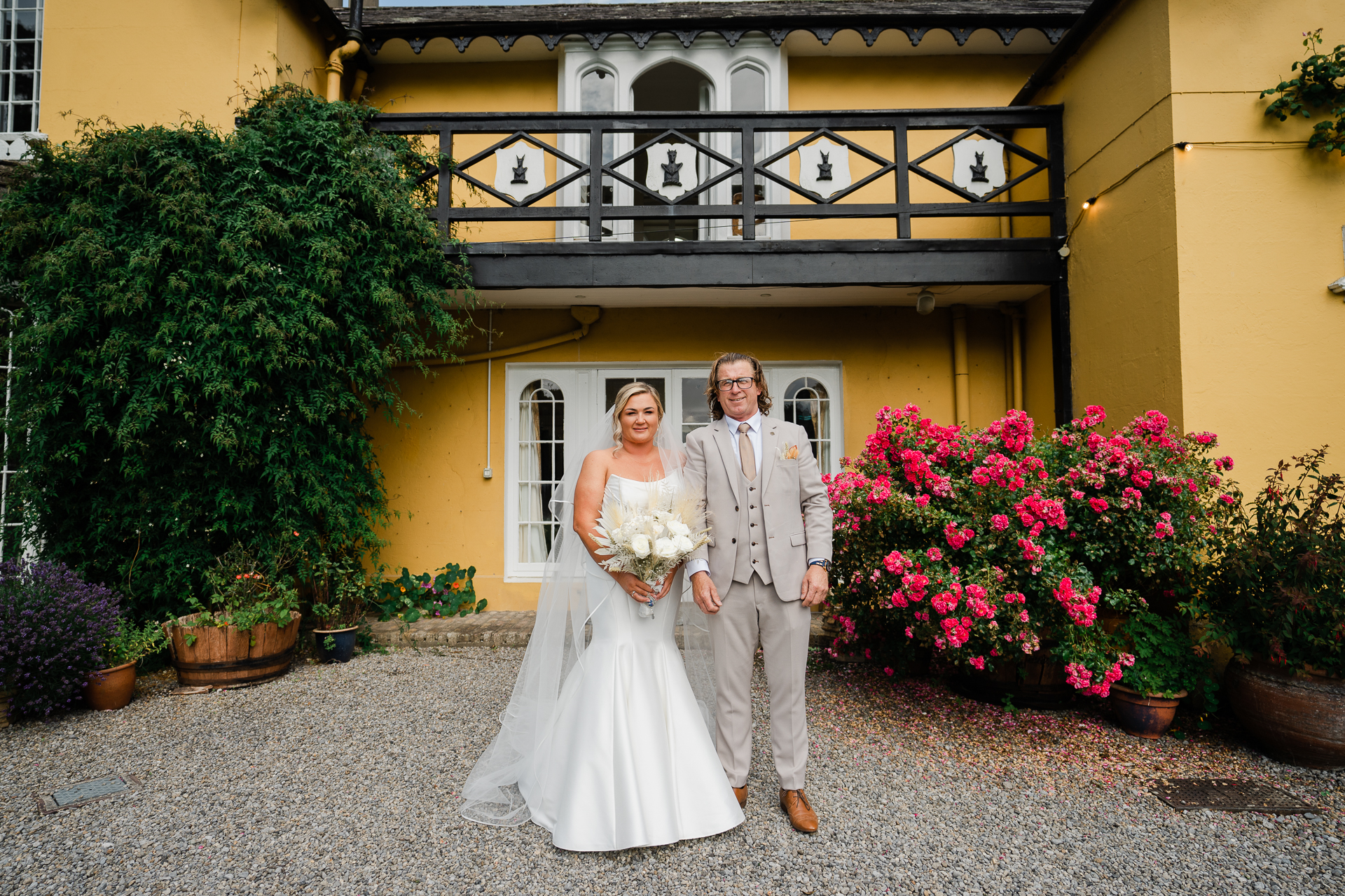 A man and woman posing for a picture in front of a house