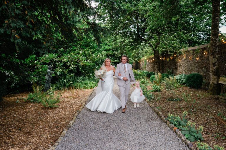 A man and woman holding hands with a child on a path