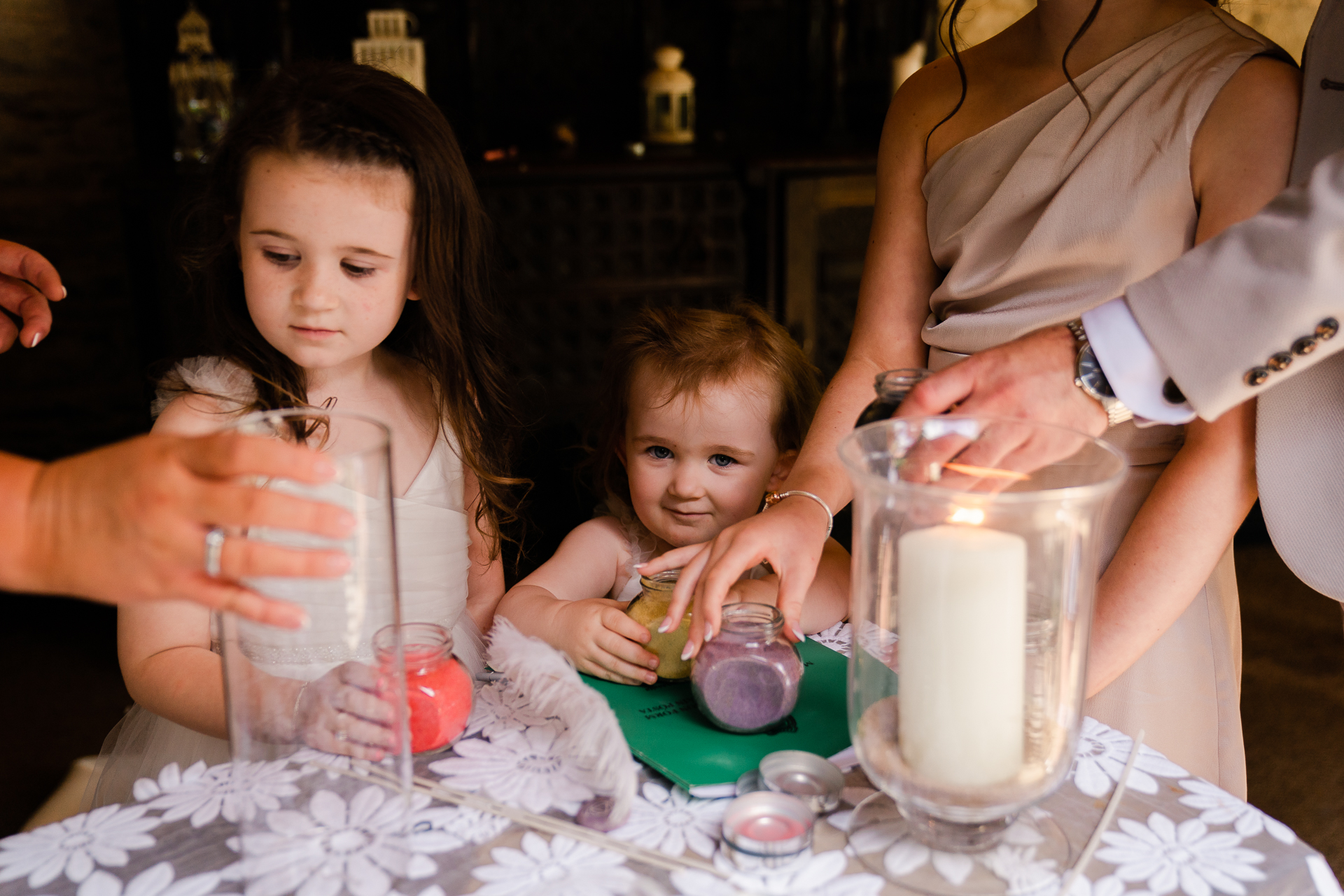 A person and a child sitting at a table with a baby