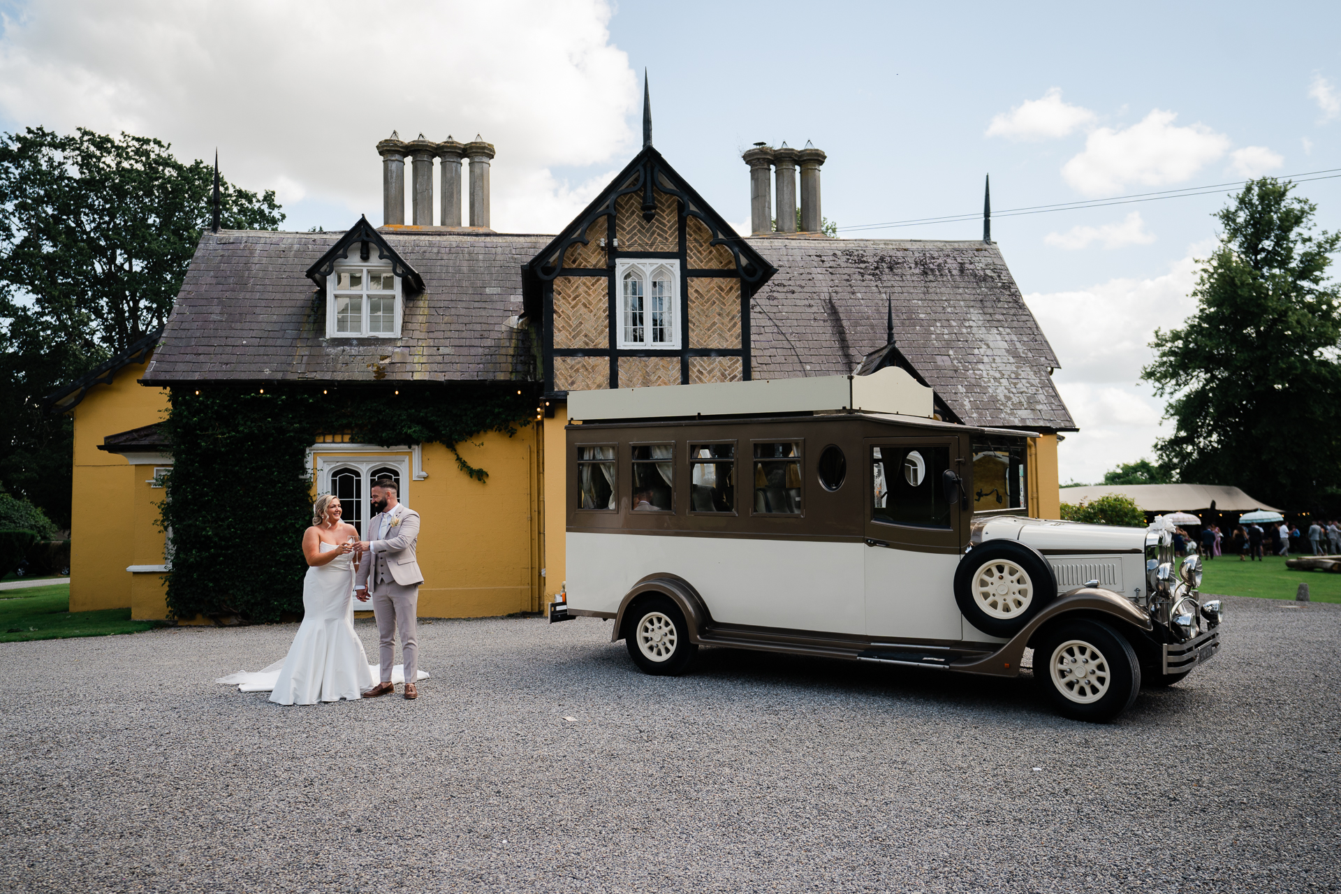 A bride and groom standing next to a bus